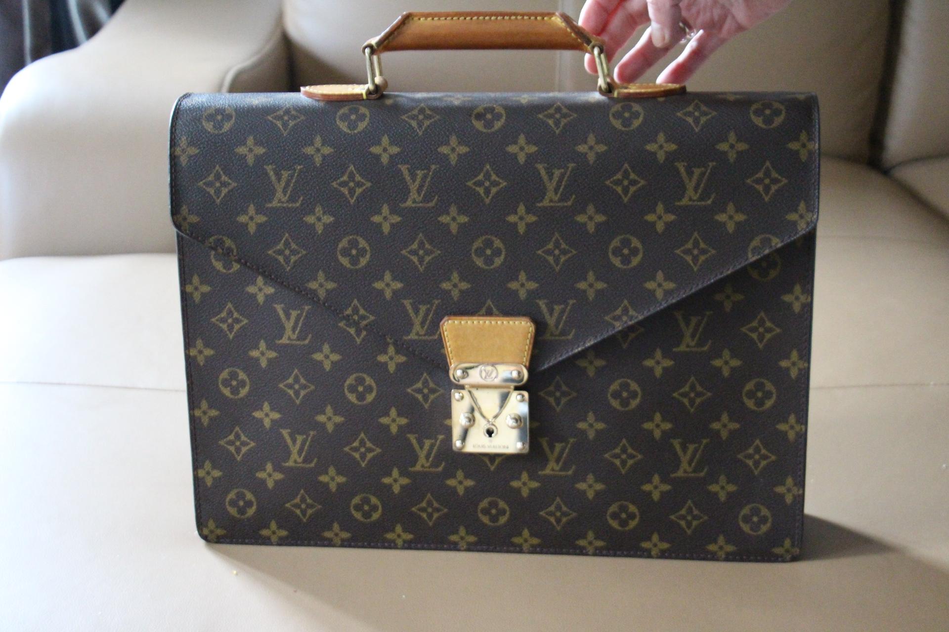 This very nice monogram canvas Louis Vuitton briefcase opens thanks to its stamped brass lock. Its comfortable leather handle is gently patinated and in very good condition.It features a flat pocket on its back.
This beautiful Vuitton piece of