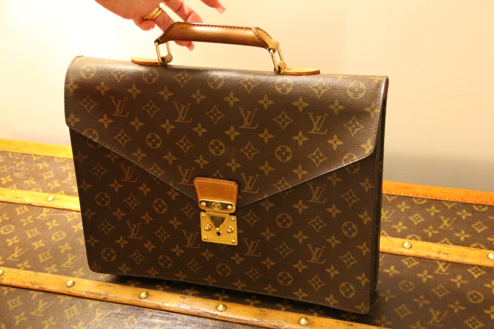 This very nice monogram canvas Louis Vuitton briefcase opens thanks to its stamped brass lock. Its comfortable leather handle is gently patinated and in very good condition.It features a flat pocket on its back.
This beautiful Vuitton piece of