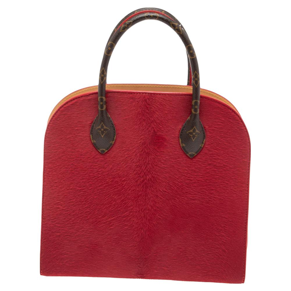 This Louis Vuitton Iconoclasts bag is made of monogram canvas and contrasted with red calf hair and gold-tone studs. It has two handles on top, metal studs on the base, and a leather-lined interior.

Includes: Original Dustbag, Info Booklet, Leather