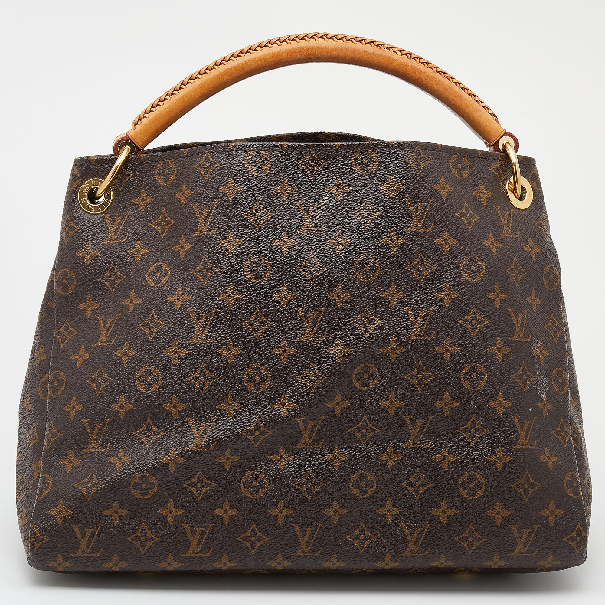 Flaunt this Louis Vuitton Artsy bag like a fashionista! Crafted from their signature monogram canvas and leather, this bag features an open top that reveals an Alcantara-lined interior, spacious enough to carry all your essentials. The bag is