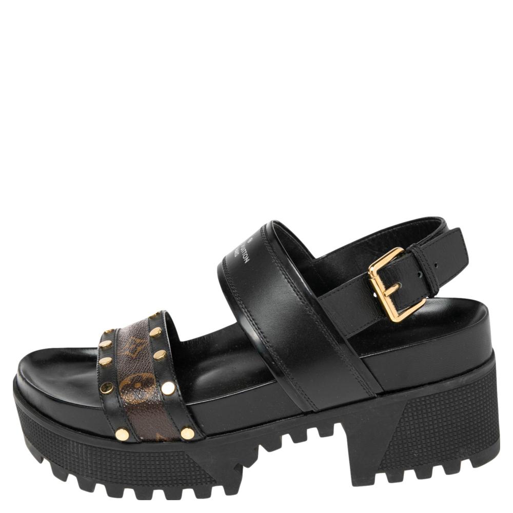 How stylish, modern, and chic do these sandals from Louis Vuitton look! They are crafted from black leather featuring brown monogram coated canvas straps on the vamps, buckled slingbacks, and rubber platforms. Pair them with smart denims for a