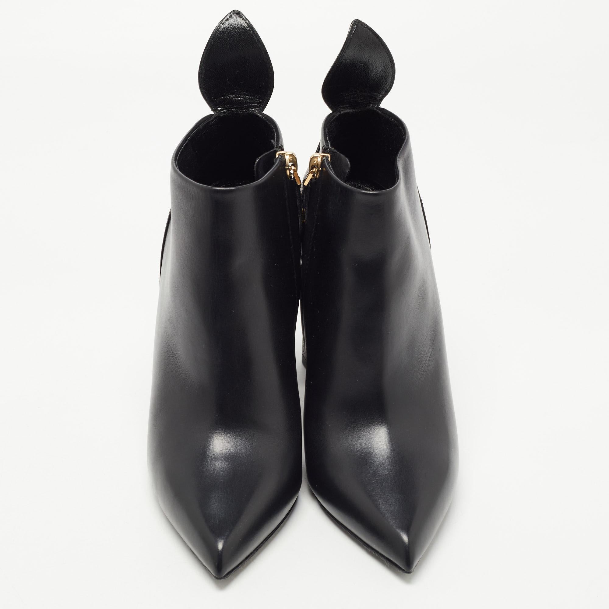 These ankle boots from Louis Vuitton were made to delight the tastes of all fashion-forward ladies. The pointed-toe ankle boots are covered in black leather and detailed with monogram canvas on the counters and on the flower-shaped heels. The boots