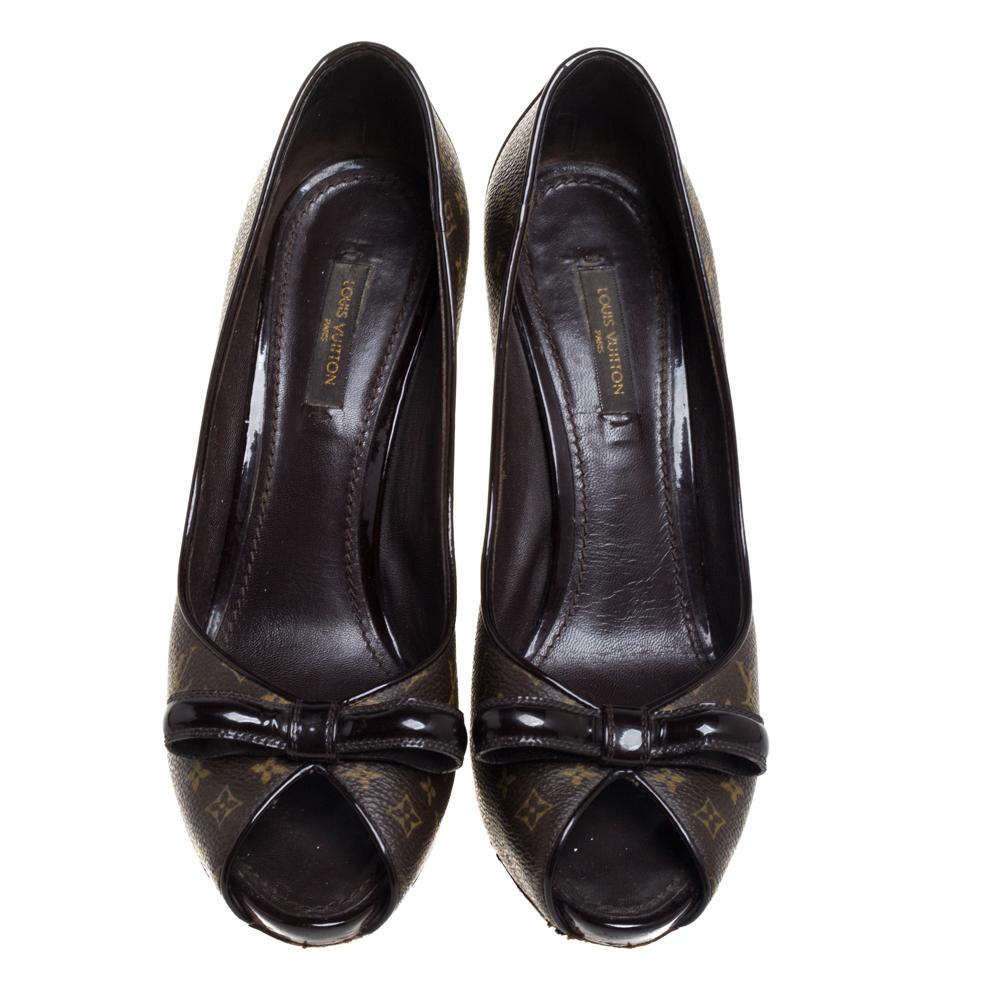 This pair of high-heeled peep-toe pumps from Louis Vuitton redefines feminity and class. They feature the label's iconic monogram canvas in brown, finished off with patent leather trims. Adorned with bows on the uppers, these beauties are ready to