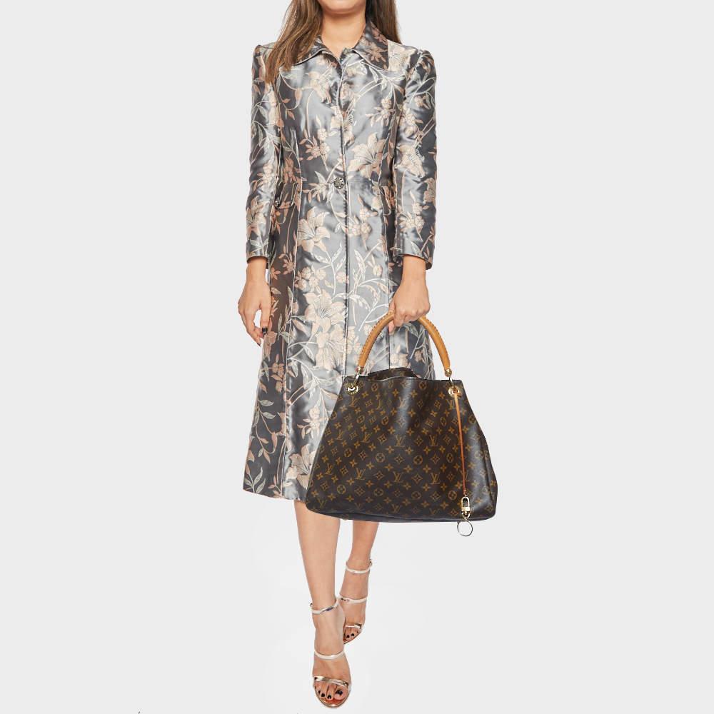 Flaunt this Louis Vuitton Artsy bag like a fashionista Crafted from their signature monogram canvas this bag features an open top that reveals an Alcantara lined interior spacious enough to carry all your essentials. The bag is completed with metal