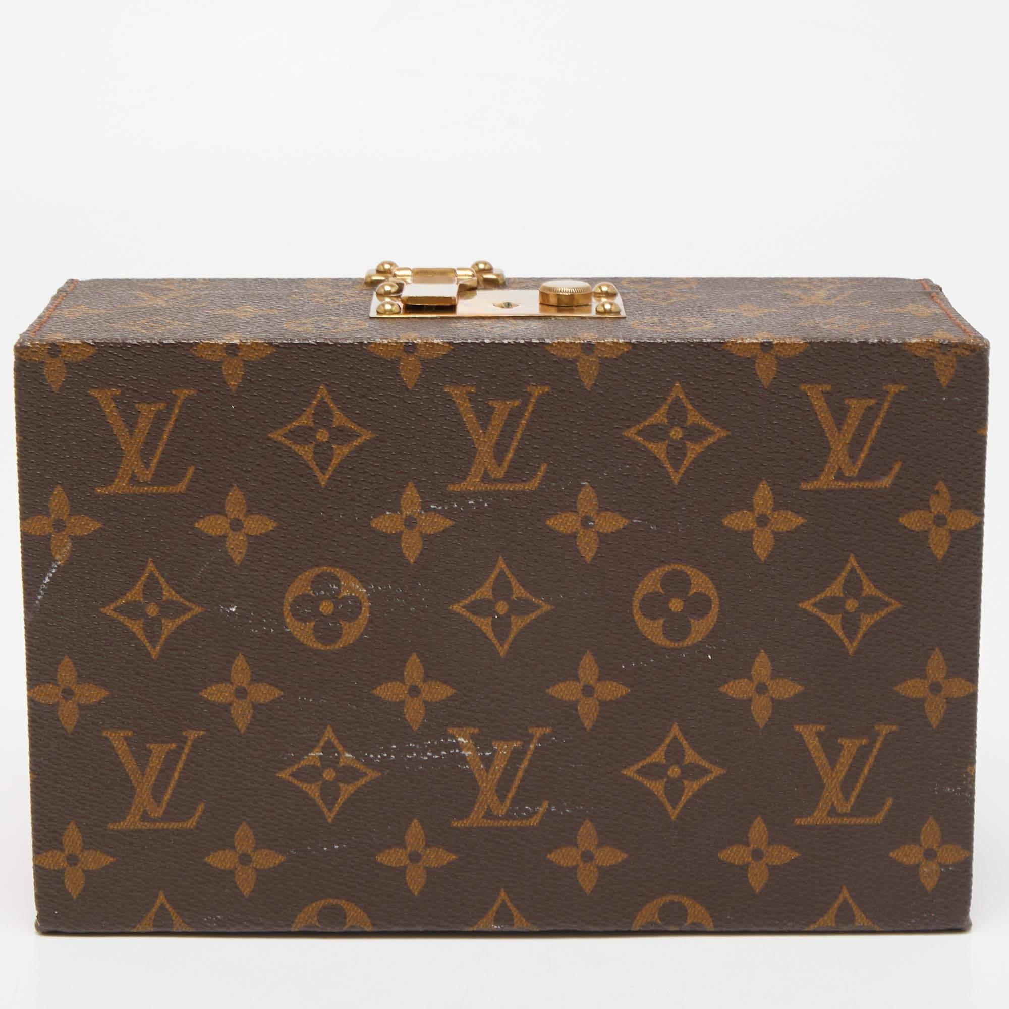 A vintage-inspired luxurious accessory, this jewelry case by the House of Louis Vuitton is crafted to offer the finest. Made from Monogram canvas, it features a sturdy silhouette with a sturdy top handle, leather trims, and gold-tone metal hardware.