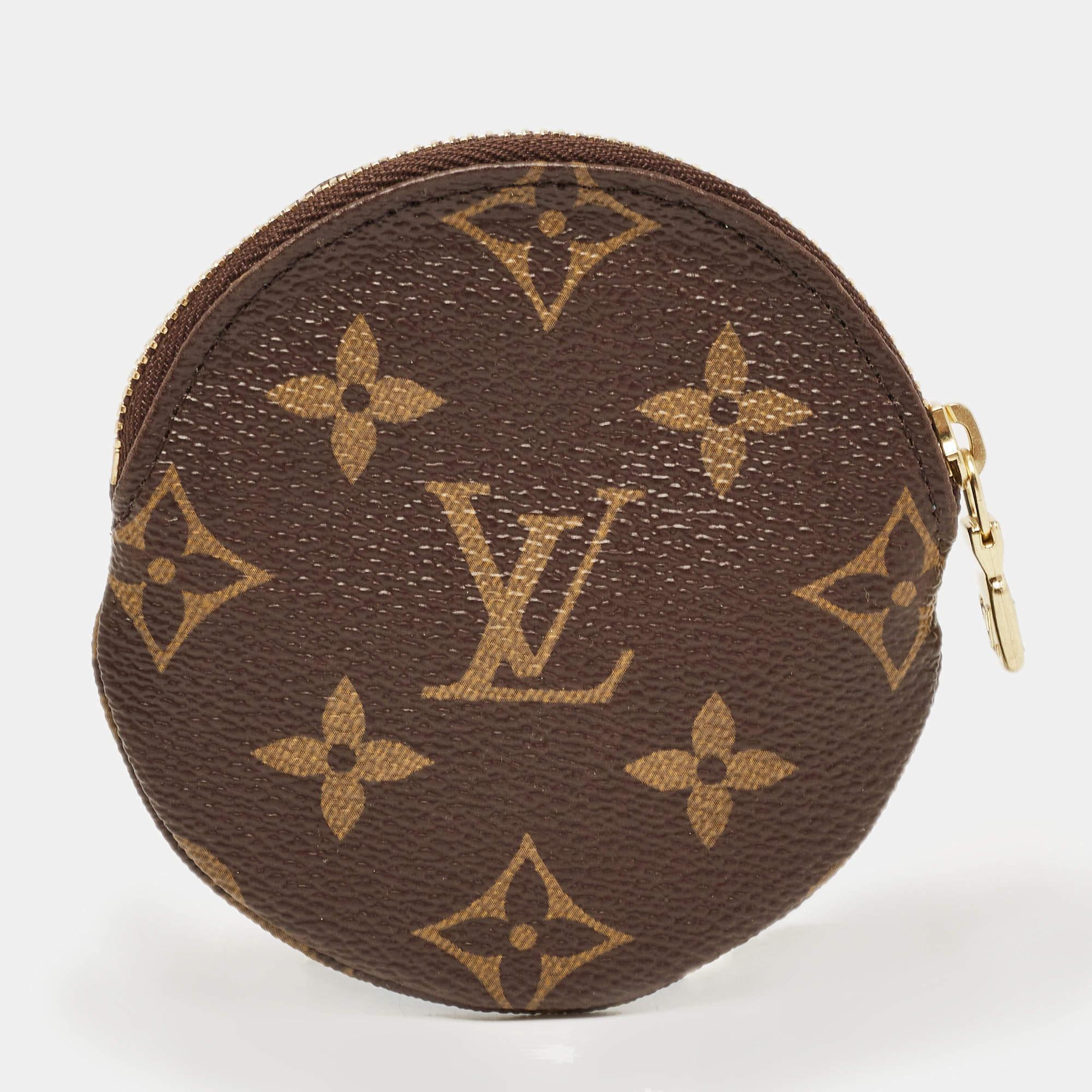 The Louis Vuitton coin purse is a petite and festive accessory featuring the iconic monogram pattern. Adorned with a charming Christmas-themed Vivienne illustration, it is a stylish and compact essential for storing coins and small
