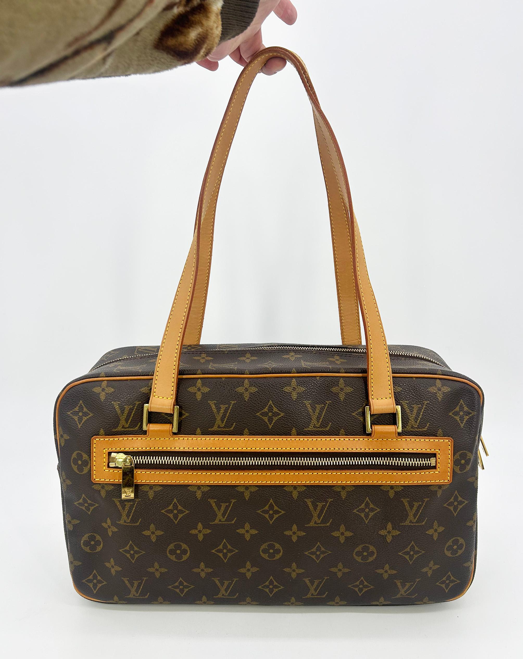 Louis Vuitton Monogram Canvas Cite GM Shoulder Bag Tote in very good condition. Signature monogram canvas exterior in brown and tan LV print trimmed with tan leather piping and double shoulder strap handles and sparkling golden brass hardware. Front