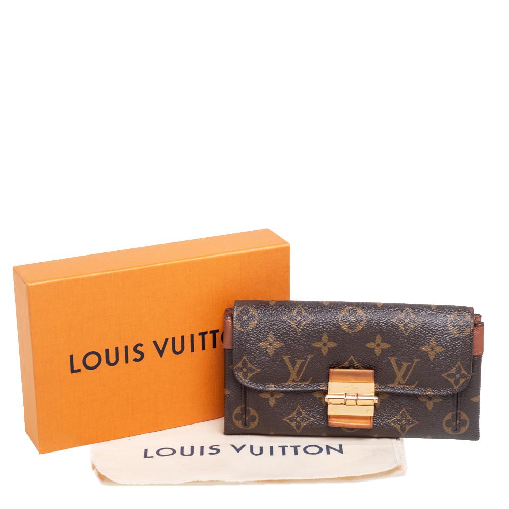Made of signature Monogram canvas, this Elysee wallet from Louis Vuitton is a gorgeous creation. The flap with a metal lock closure opens to an interior housing multiple card slots, a zipped pocket, and open compartments. This wallet is complete