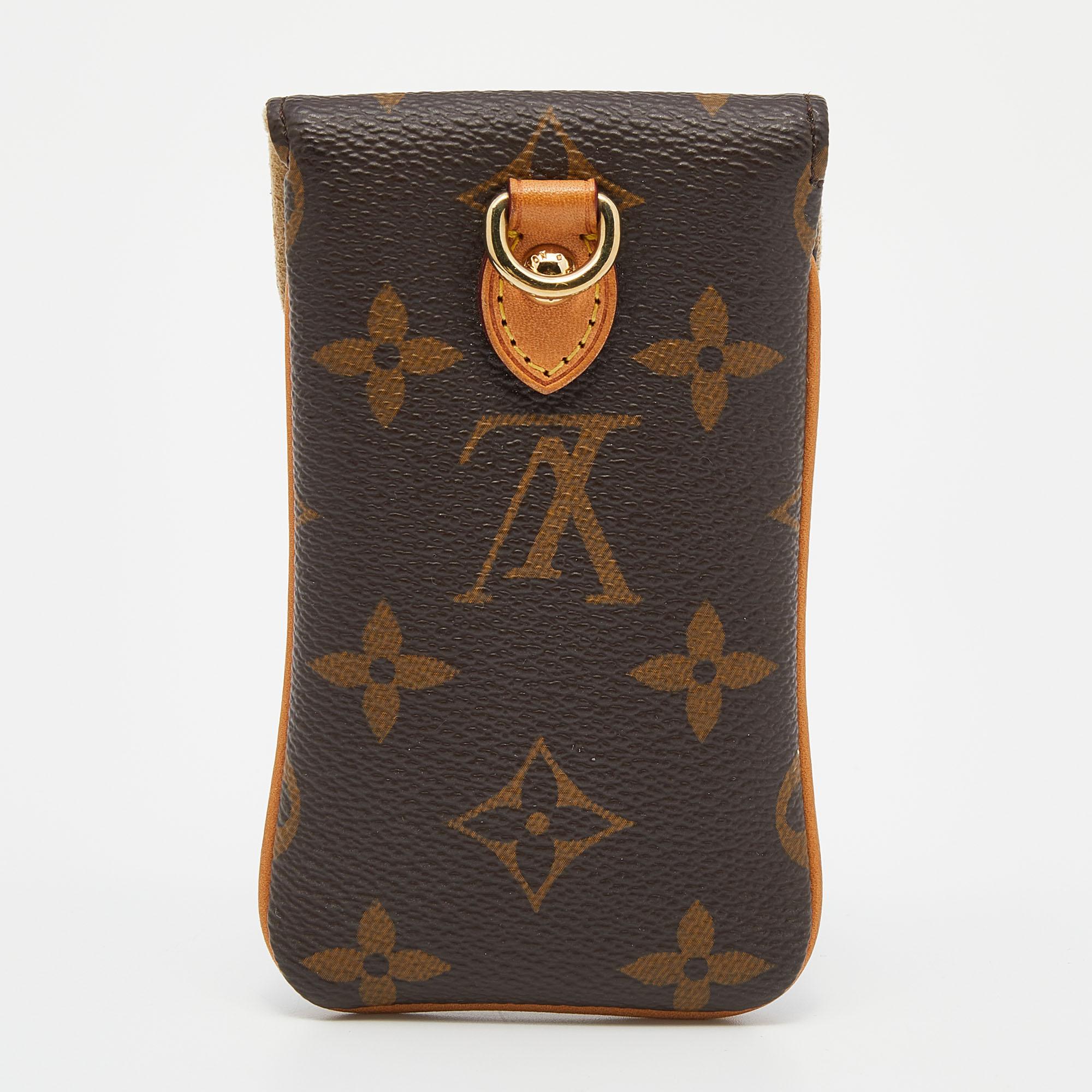 Crafted using monogram canvas, this phone case by Louis Vuitton is sized to safely house your phone. It has a fine finish with a press lock on the flap.