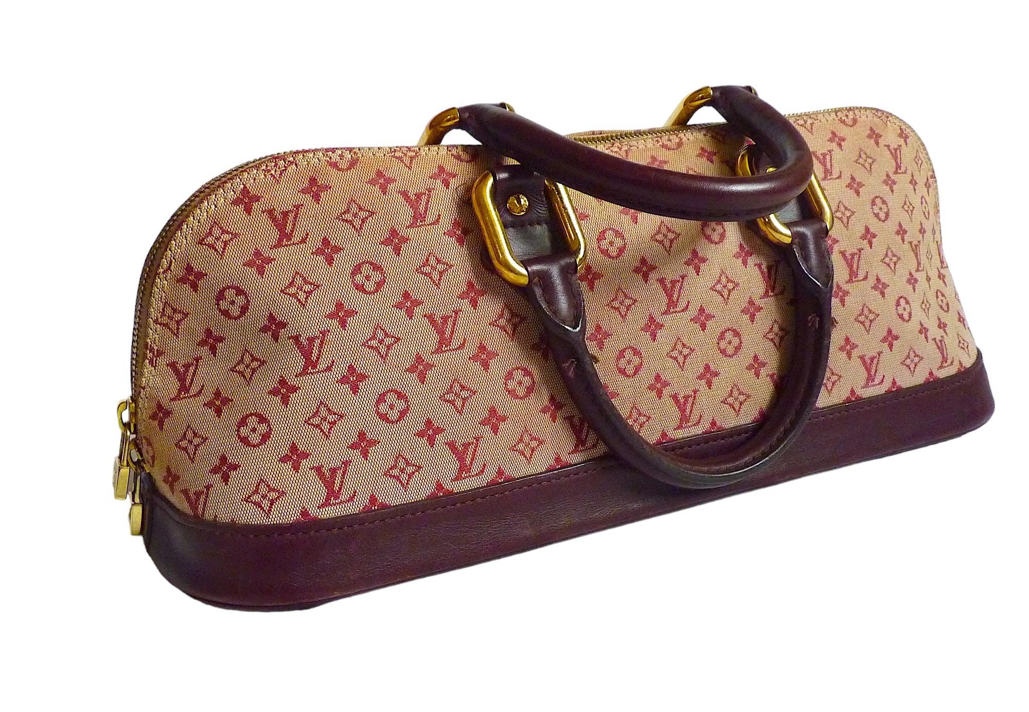 A very rare vintage Louis Vuitton  Monogram Handbag. The bag is made of Burgundy/Beige monogram canvas, with burgundy leather trim. 
It features gold-toned hardware. The interior is lined with beige-like fabric and leather. It consists of one major
