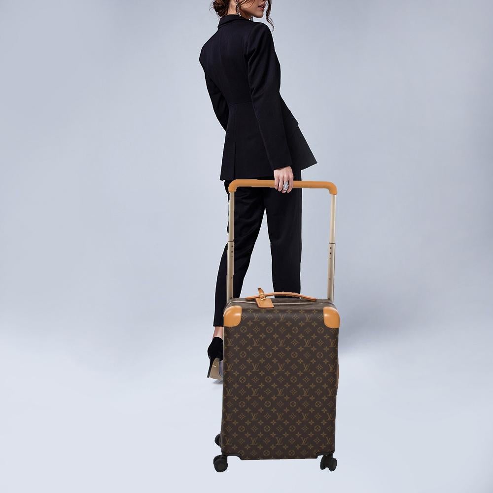 To elevate your traveling experience, Louis Vuitton brings you this reliable Horizon 50 suitcase. It has been crafted from the brand's signature monogram canvas, aluminum, and leather trims. Equipped with a short handle, a telescopic handle, and a