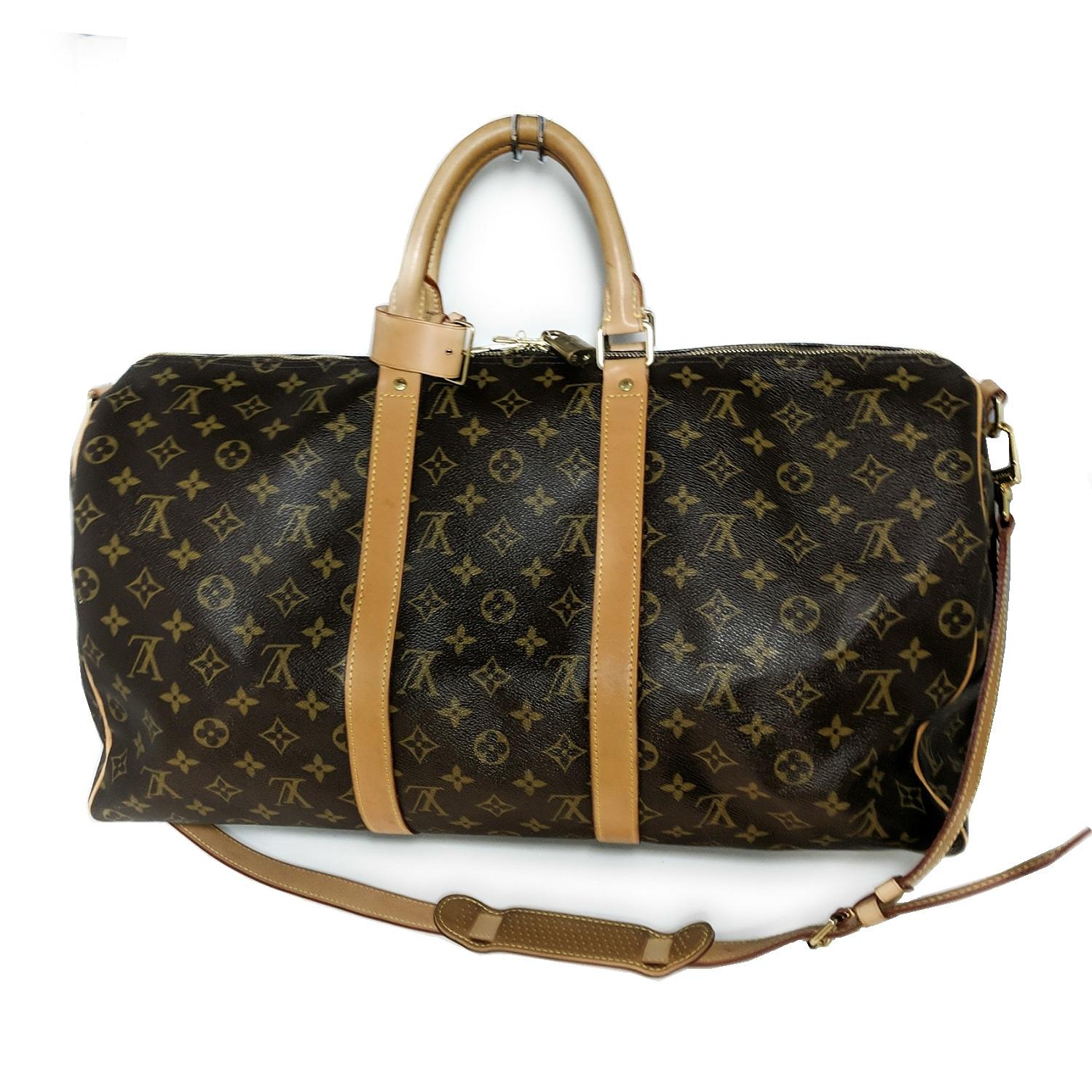 Brown and tan monogram coated canvas Louis Vuitton Keepall 50 with golden brass hardware, tan Vachetta leather trim, dual rolled top handles, brown canvas lining, and two-way zip closures at top. Retail price is $1,580.

An icon since its appearance