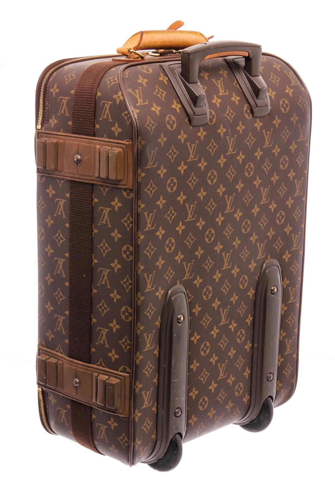 Brown and tan monogram coated canvas Louis Vuitton Pégase 50 with brass hardware, single exterior slip pocket, brown nylon lining, compression straps at interior, leather button hanger straps tan vachetta leather trim, single flat top handle,