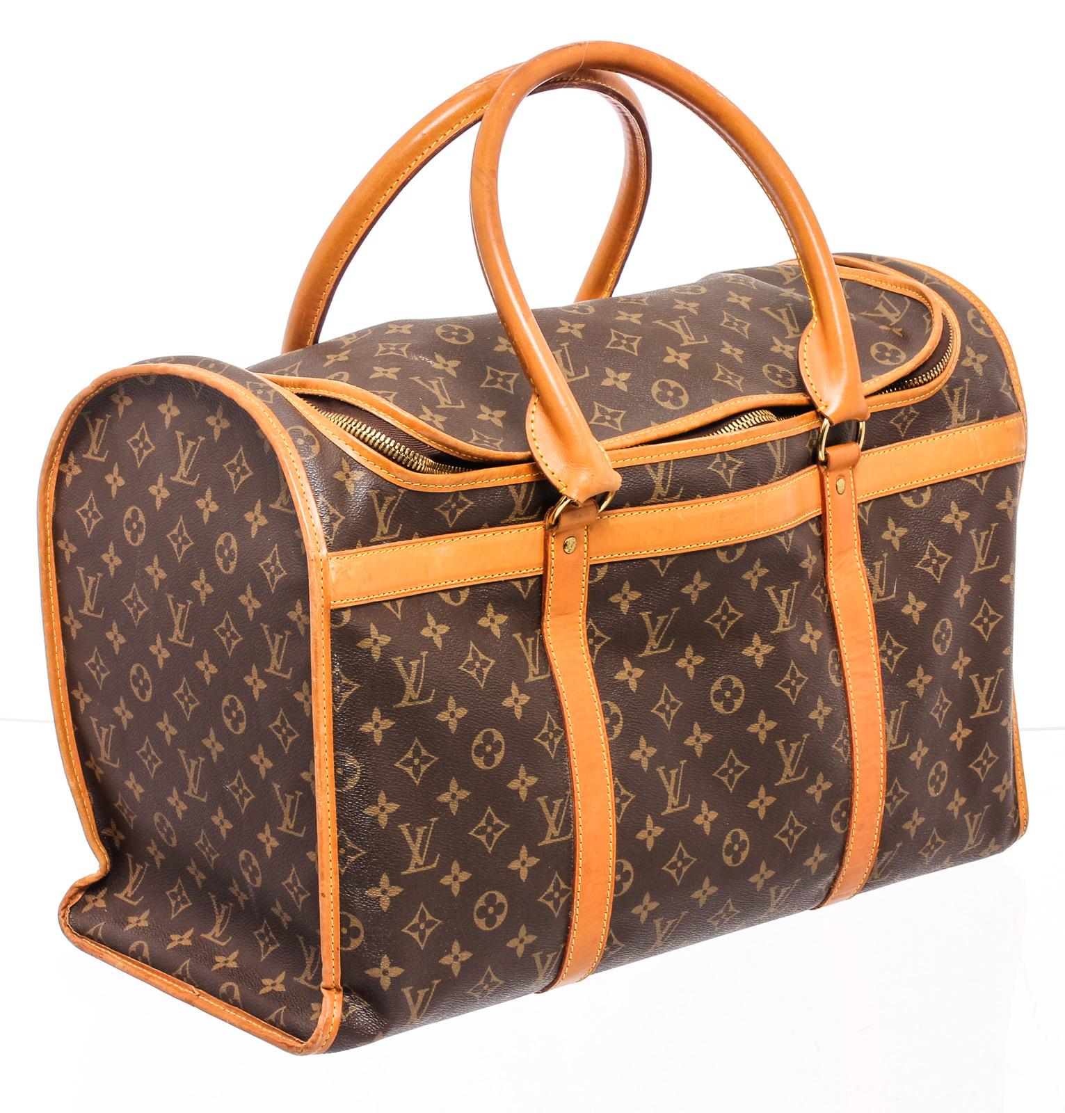 Sac de transport pour chien Sac Chien 40 en toile enduite monogramme marron et fauve avec quincaillerie en laiton, garniture en cuir vachette fauve, deux poignées roulées sur le dessus, filet sur le côté avec fermetures à boutons-pression, étiquette
