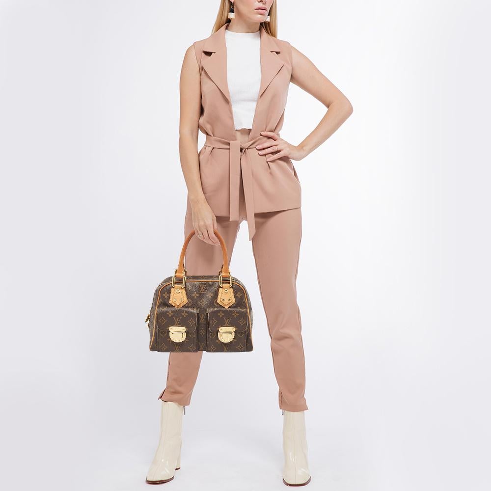 Effortlessly carry this stylish and elegant Manhattan handbag by Louis Vuitton. Crafted from classic monogram canvas, this bag will effortlessly complement any color you might wear. The exterior has dual front pockets with push lock closures and