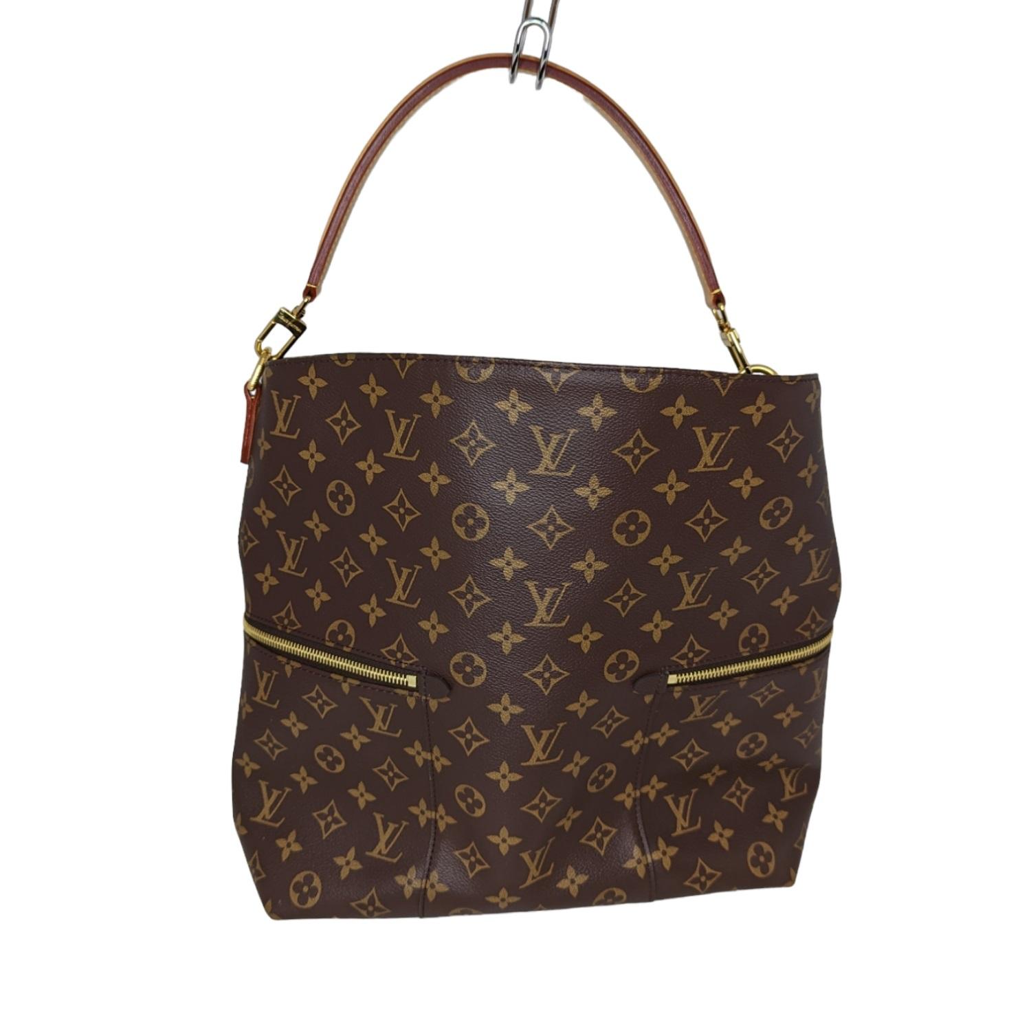 This chic hobo is finely crafted of classic Louis Vuitton monogram coated canvas. The bag features zipper pockets on either side, a vachetta leather top handle and polished brass hardware. The top opens to a microfiber interior with patch pockets.