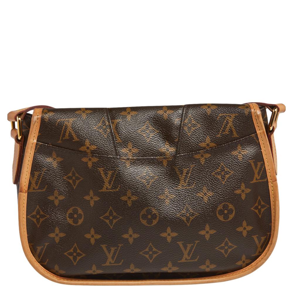 A messenger bag like this stylish yet functional Menilmontant PM from Louis Vuitton is a closet must-have. This bag is crafted from Louis Vuitton's iconic monogram canvas with leather trims. The exterior features a flap front closure, an adjustable