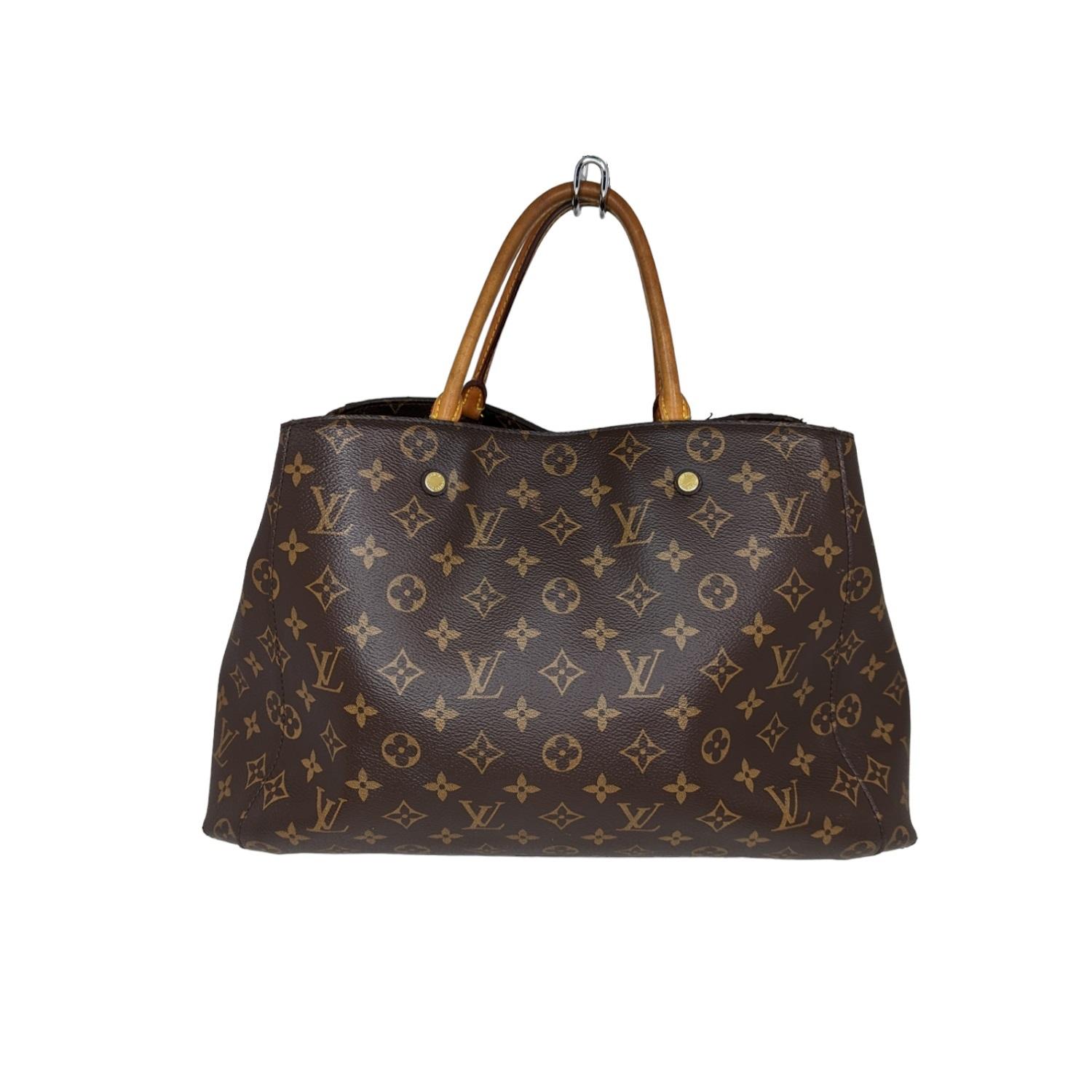 This chic tote is crafted of Louis Vuitton monogram coated toile canvas. The shoulder bag features vachetta cowhide leather rolled leather top handles with an optional monogram canvas shoulder strap complemented with polished brass clasps. The top