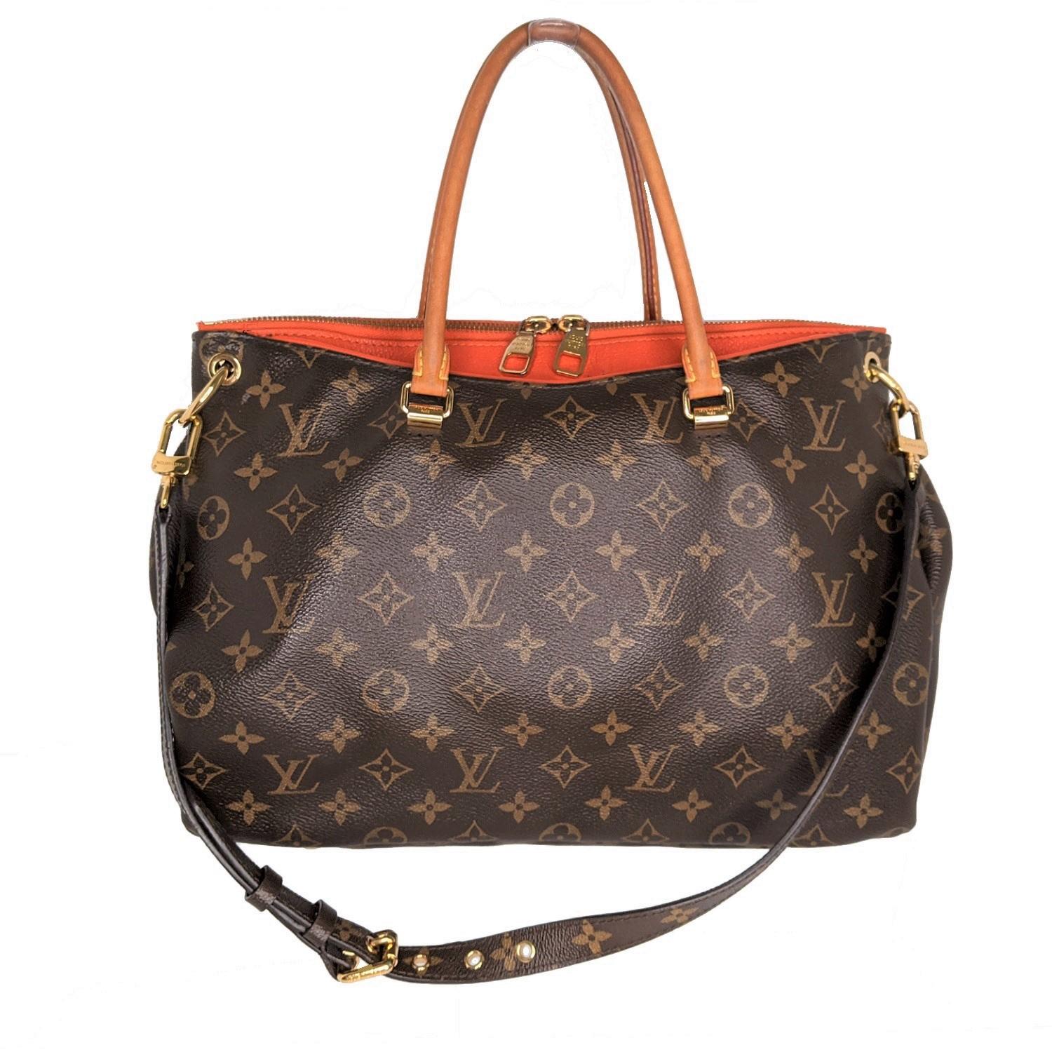 Brown and tan monogram coated canvas Louis Vuitton Pallas tote with brass hardware, single flat shoulder strap featuring buckle adjustment, dual rolled top handles, tan Vachetta and tangerine leather trim, protective feet at base, dual exterior