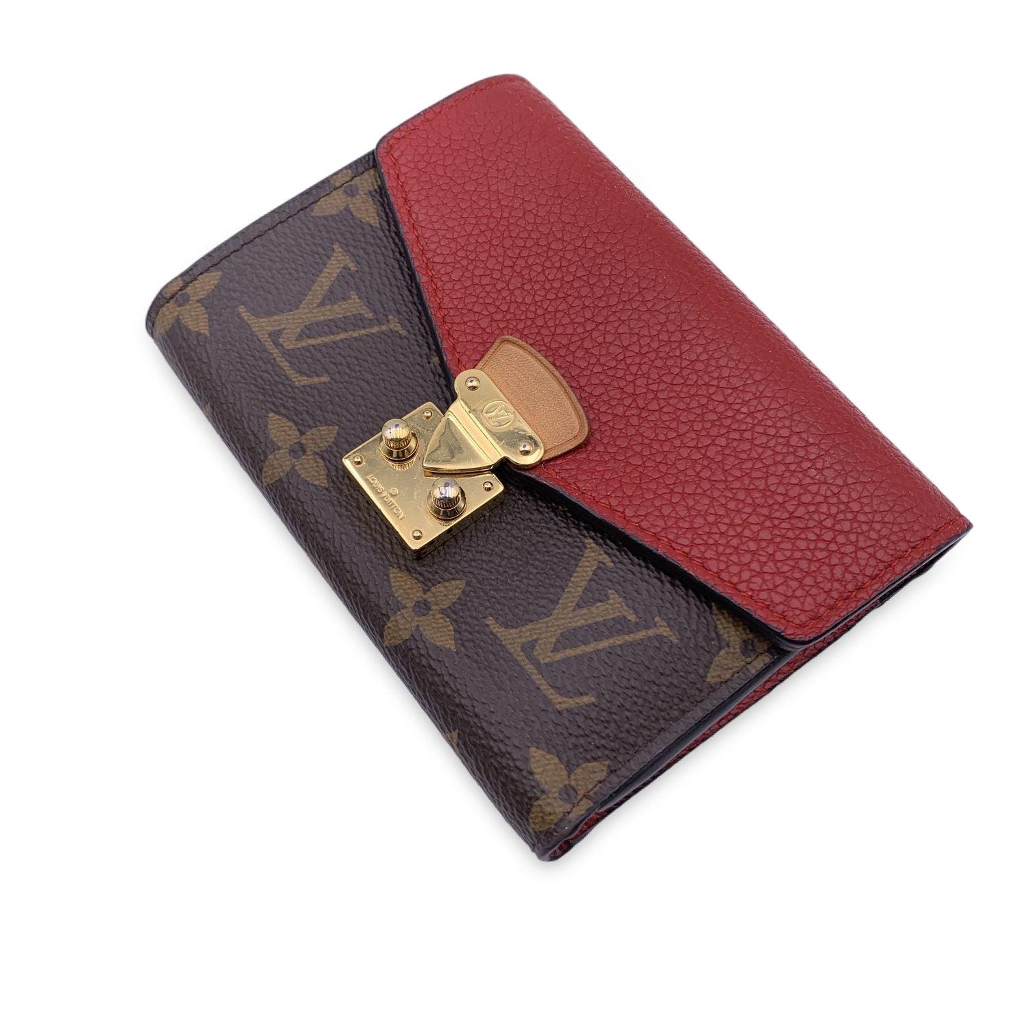 This beautiful Bag will come with a Certificate of Authenticity provided by Entrupy. The certificate will be provided at no further cost Louis Vuitton 'Pallas NM' compact wallet, in brown monogram canvas. It features a frontal flap in red calf