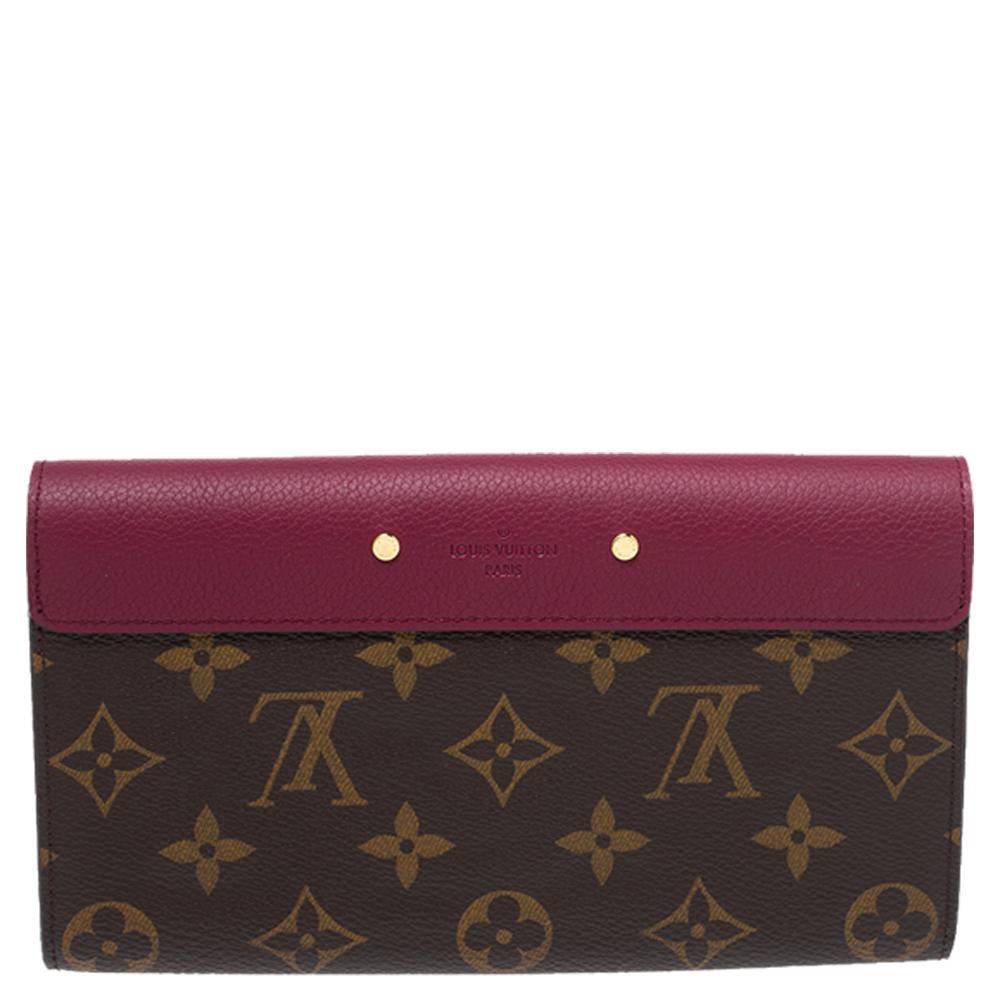 This Pallas wallet from the house of Louis Vuitton carries the signature logo-engraved S-lock in gold-tone. Crafted from monogram canvas and leather, the red-colored flap opens up to an interior with multiple card slots and a pocket with a zipper.