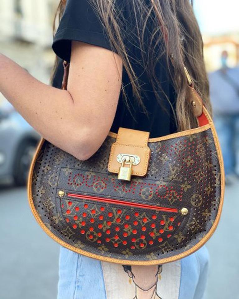 Louis Vuitton Perforierte Modelltasche aus Monogram Canvas mit Details aus Rindsleder, goldenen Beschlägen und orangefarbener Innenausstattung. Ausgestattet mit verstellbarem Griff. Verschluss mit Haken, innerlich recht groß. Die Tasche ist in gutem