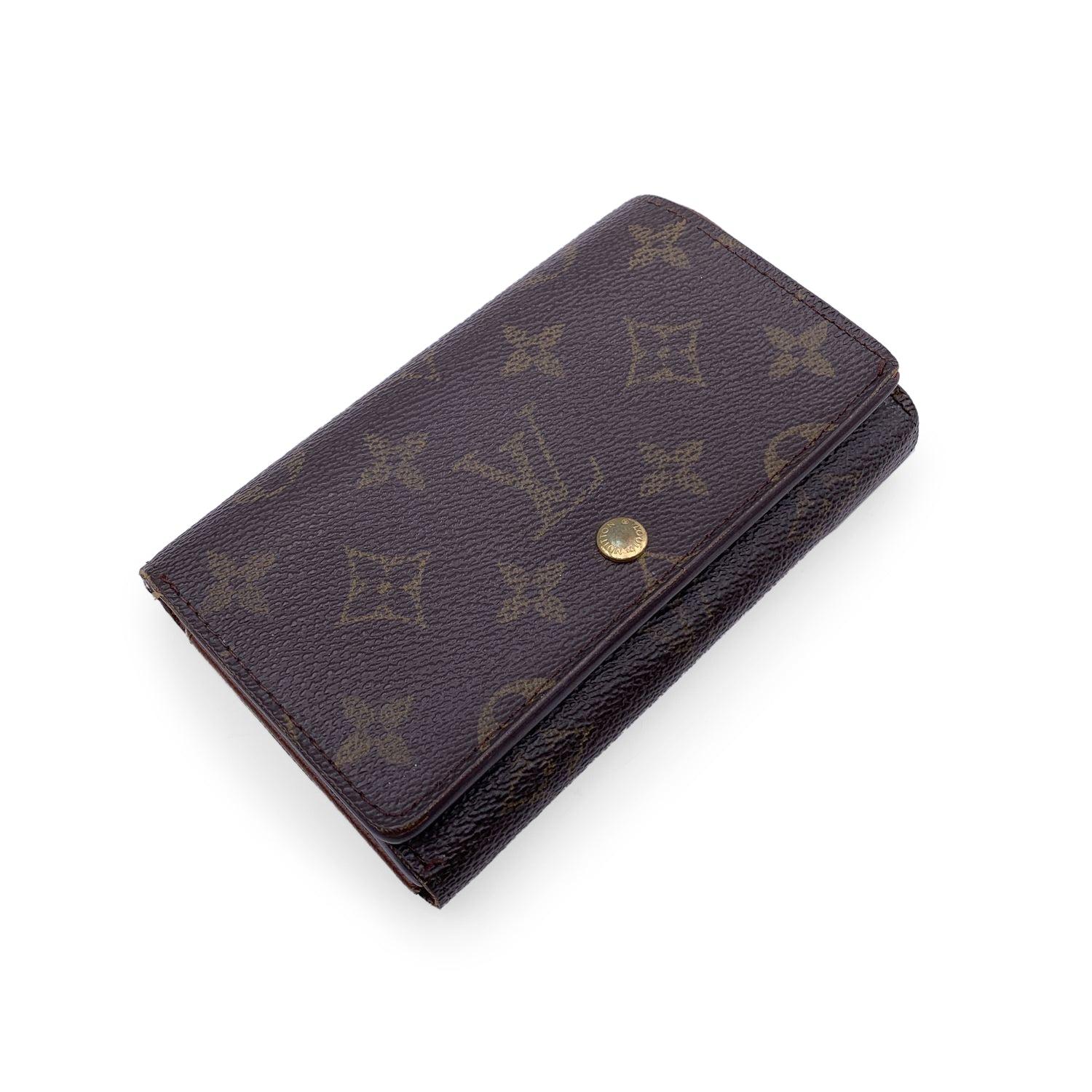 Louis Vuitton wallet, mod. Tresor. Monogram canvas. Cross grain leather lining. Flap and press stud closure. 4 open pockets, 1 middle zipped coin compartment. and 2 credit card slots. 'Louis Vuitton Paris - Made in France' engraved inside.
