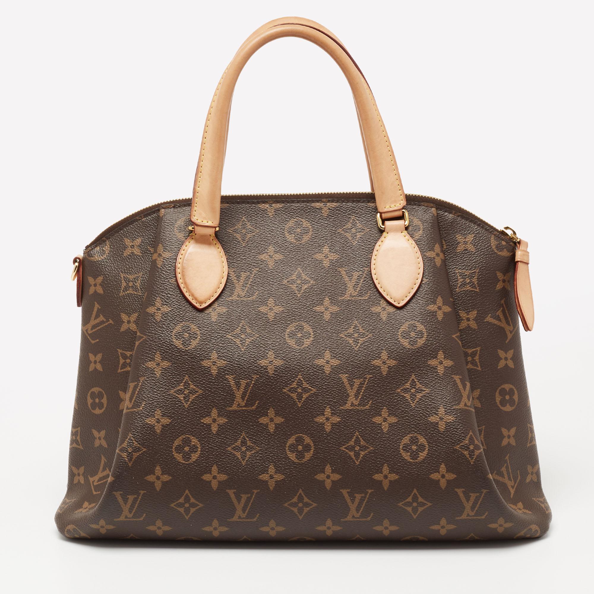 The Rivoli bag by Louis Vuitton has an undeniably appealing shape. This one is crafted from coated canvas and leather. It has a sturdy structure and the design includes a padlock on the front, two handles, and a spacious Alcantara