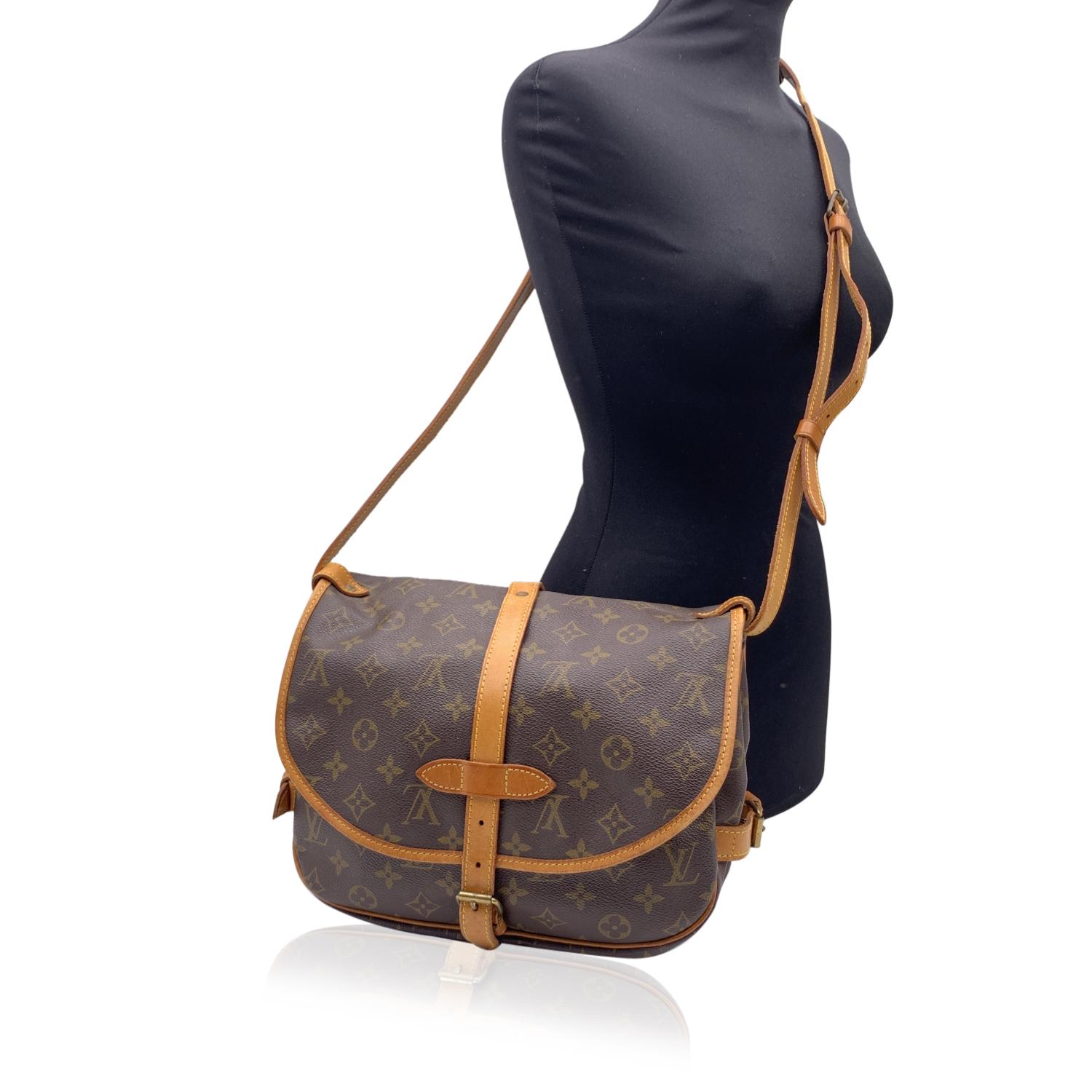 LOUIS VUITTON 'Saumur 30' inspired by equestrian 'SADDLE' bag. The legendary SAUMUR features dual front compartments, held tightly together at the sides with belt-like tabs. Adjustable long shoulder strap with pad for added comfort. Monogram canvas