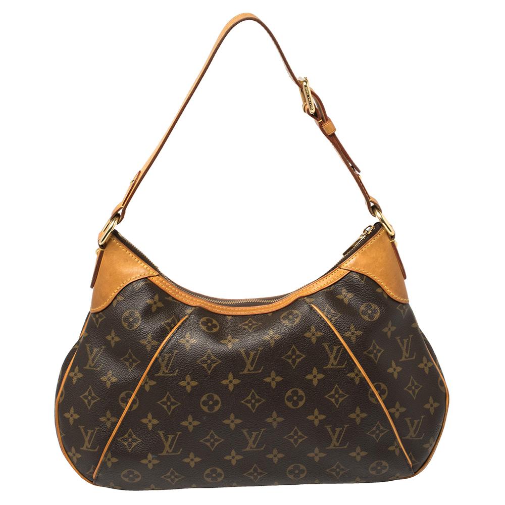 This gorgeous Louis Vuitton bag has been crafted out of monogram-coated canvas. It features a single adjustable top leather handle and brand name in gold-tone metal. A top zipper closure opens to a roomy canvas-lined interior and has a slide pocket.