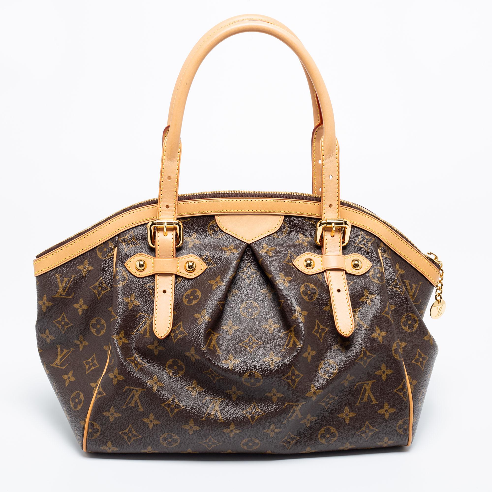 The gorgeous LV Tivoli bag is an enduring style companion. Crafted from monogram canvas, the bag has leather trims, two leather handles, and protective metal feet. It has a top zipper that opens to reveal a spacious canvas interior meant to easily