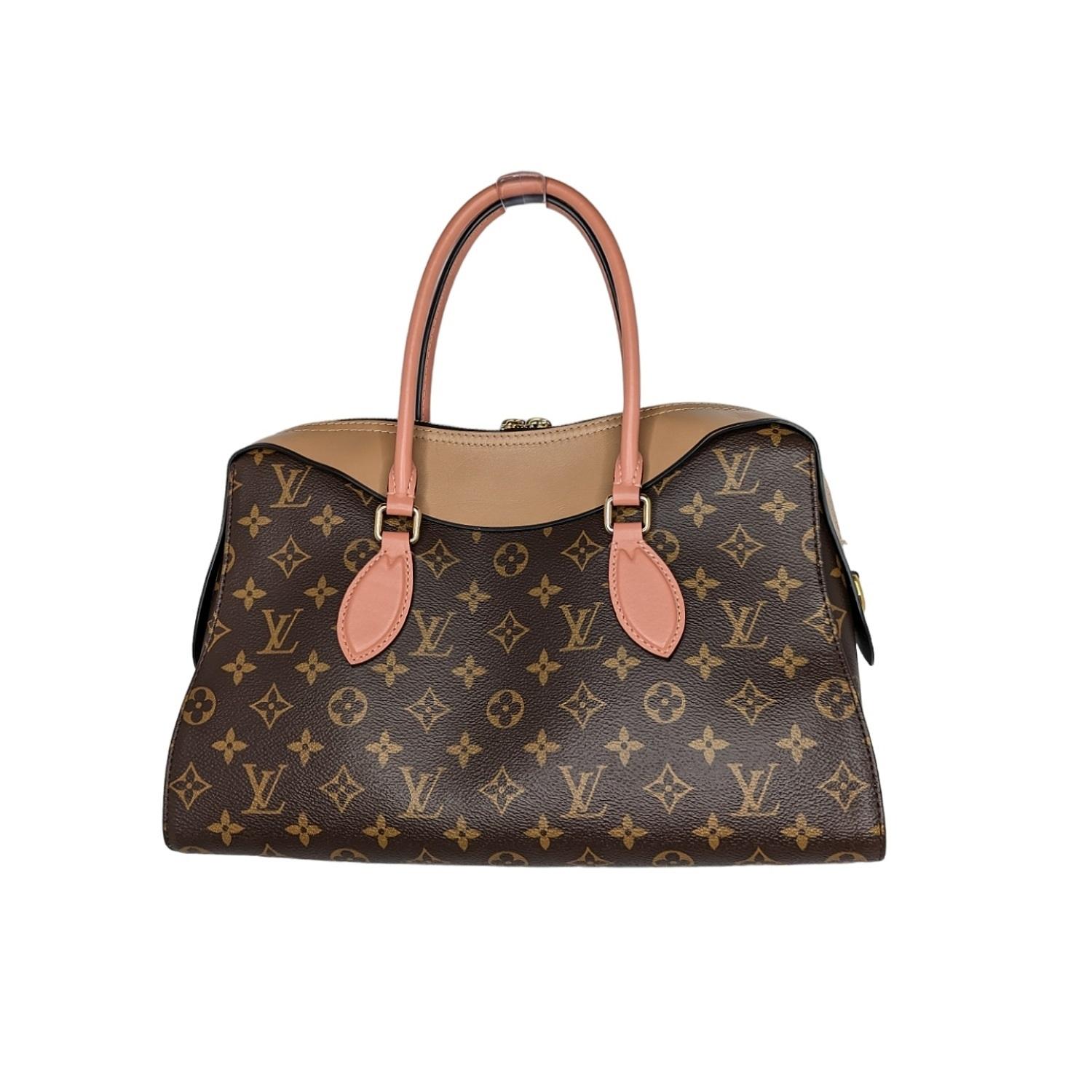 This chic handbag is crafted of Louis Vuitton monogram toile canvas with cowhide leather accents in pink and tan. The bag features rolled cowhide pink leather top handles with polished brass links. The top zipper opens to a beige microfiber interior