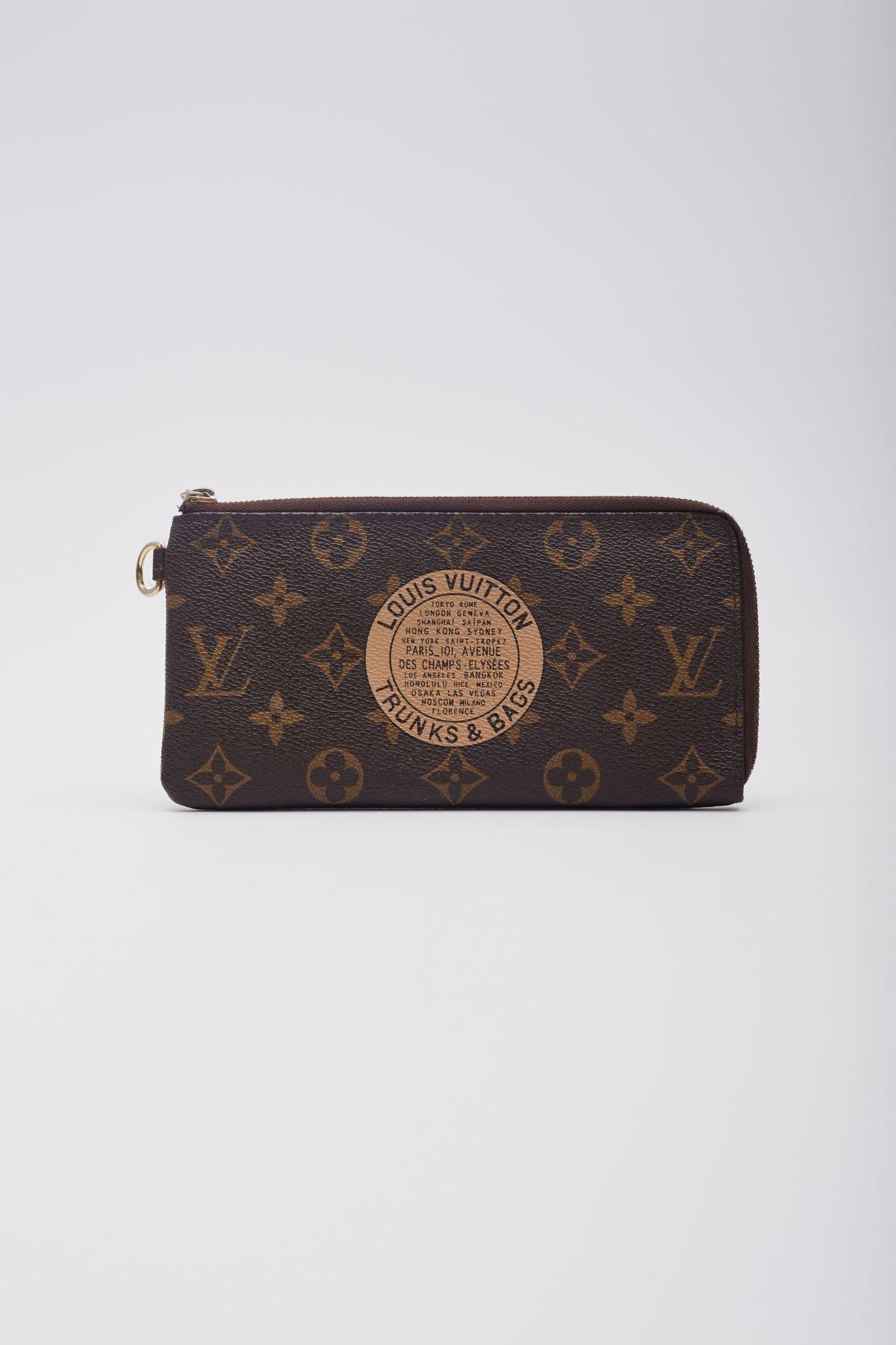 This wallet is made of Louis Vuitton monogram canvas with a traditional Trunks and Bags logo in beige. The wallet has a handy D ring, a back zipper pocket, a wrap around zipper and opens on two sides to a beige cross grain leather interior with