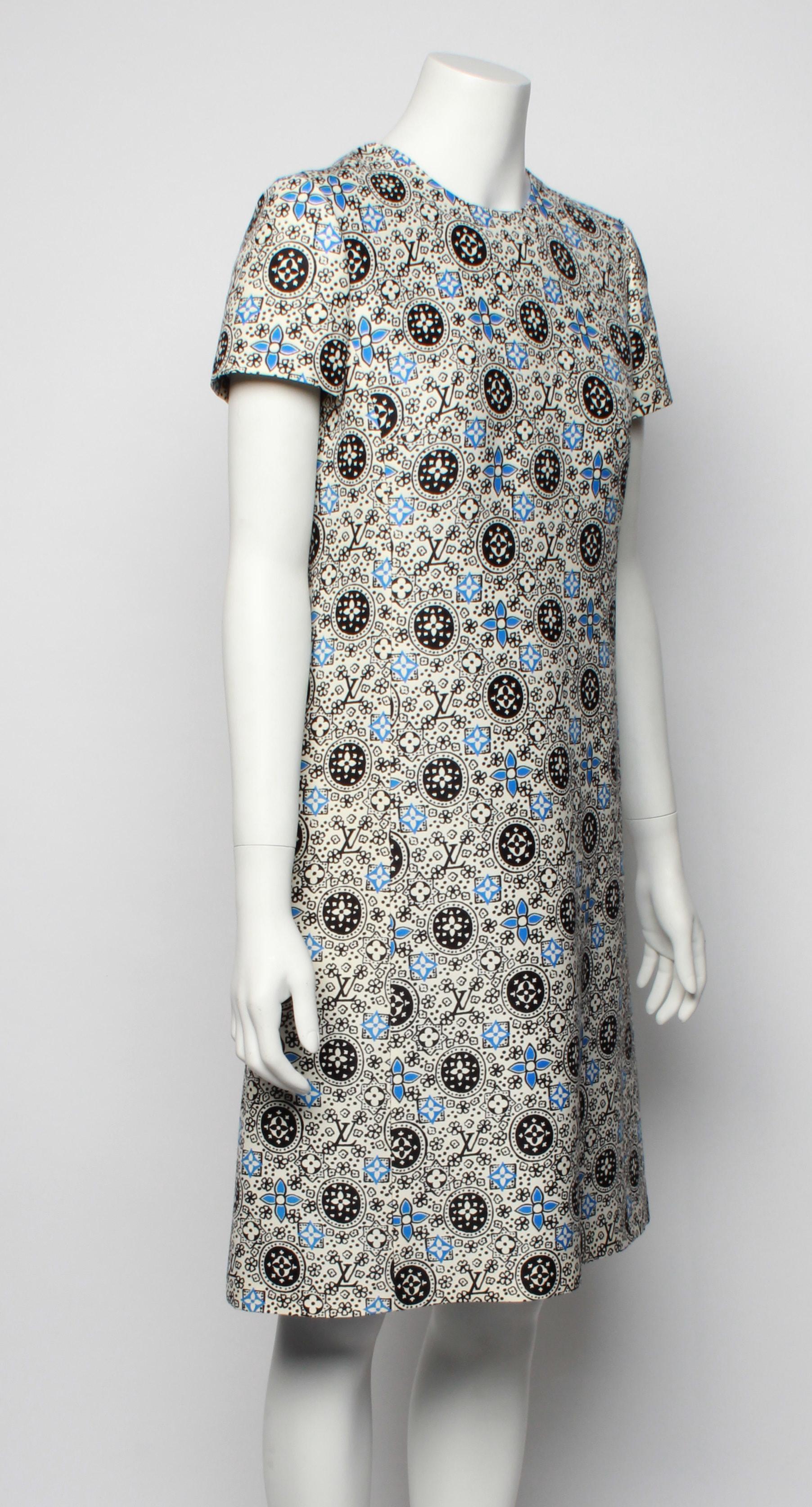This short A-line dress is inspired by the styles of the 1960s and 70s printed in LV iconic logo and 4 petal flower. White base with black and blue print. 
Features short sleeve, exposed metal zipper with LV branding and contrast turquoise lining.
