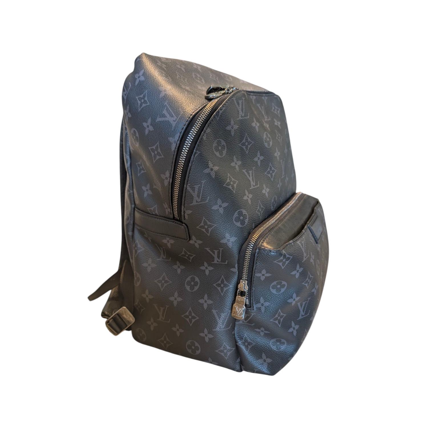 Experience luxury and sophistication with the Louis Vuitton Monogram Eclipse Discovery Backpack PM. Crafted with black coated canvas and leather trim, this backpack features silver-tone hardware and multiple pockets for easy organization. The dual