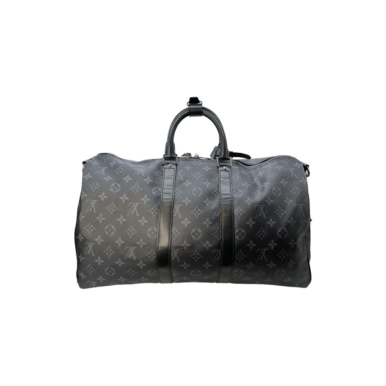 This Louis Vuitton Monogram Eclipse Keepall Bandoulière 45 was made in 2019 and it is finely crafted of the Louis Vuitton Monogram Eclipse canvas exterior with black leather trimming and silver-tone hardware features. It has a removeable and