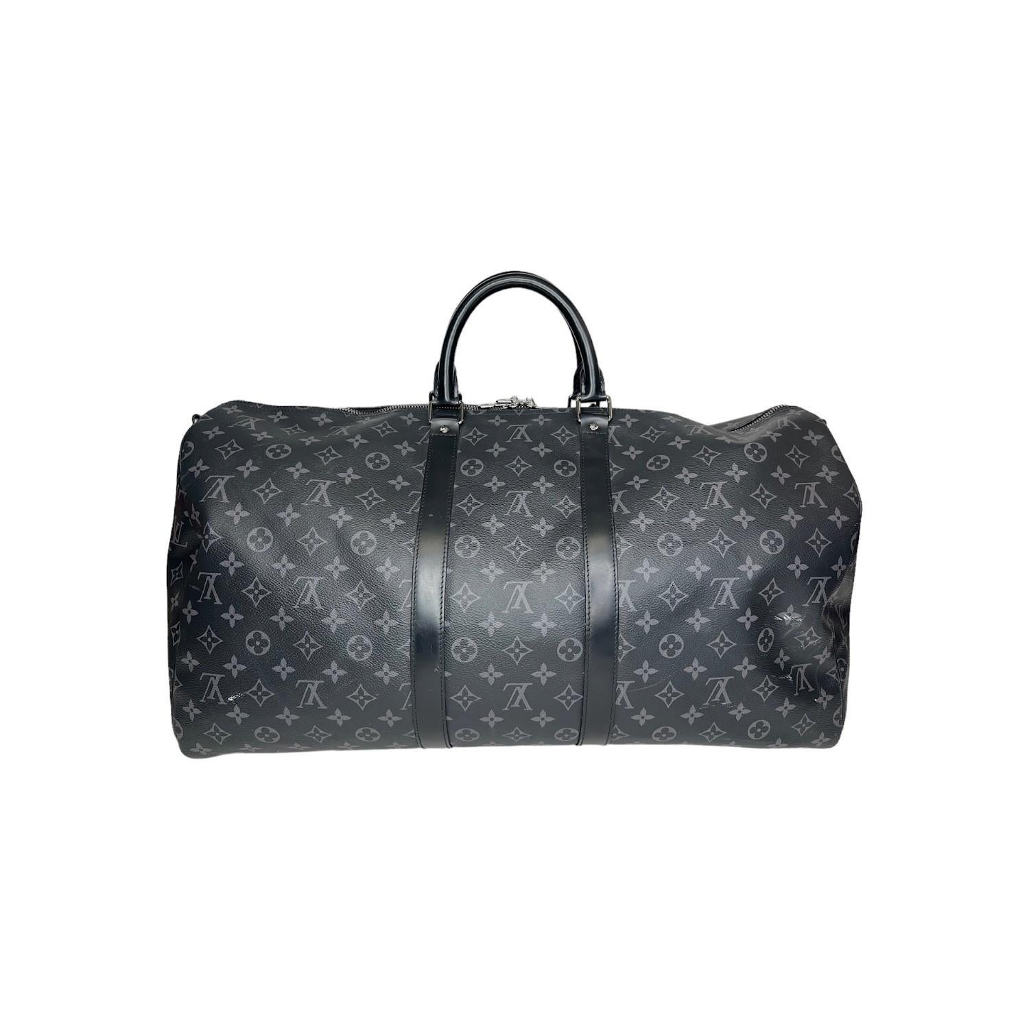 This Louis Vuitton Monogram Eclipse Keepall Bandoulière 55 travel bag was made in the 50th week of 2018 in France and it is finely crafted of the iconic Louis Vuitton Monogram Eclipse canvas exterior with black leather trimmings and silver-tone