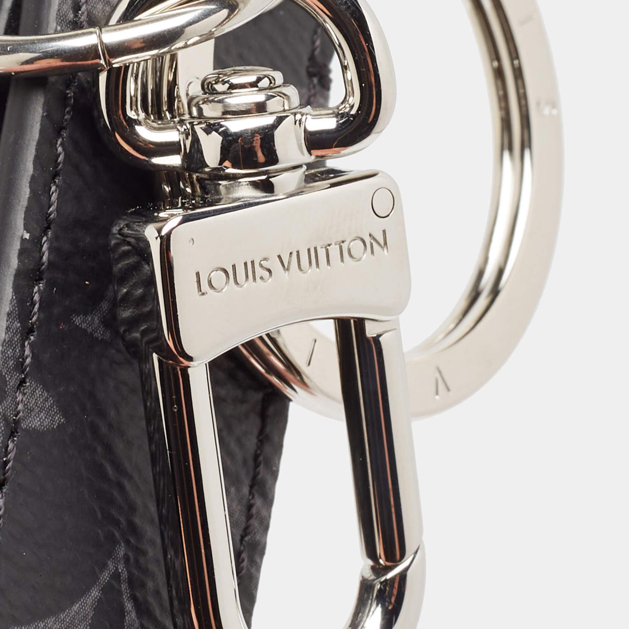 Il portachiavi Louis Vuitton presenta l'iconica mascotte Vivienne nell'elegante tela Monogram Eclipse.  combinando stile classico e charme giocoso. Questo versatile accessorio è caratterizzato da un hardware in tonalità argento lucido e da dettagli
