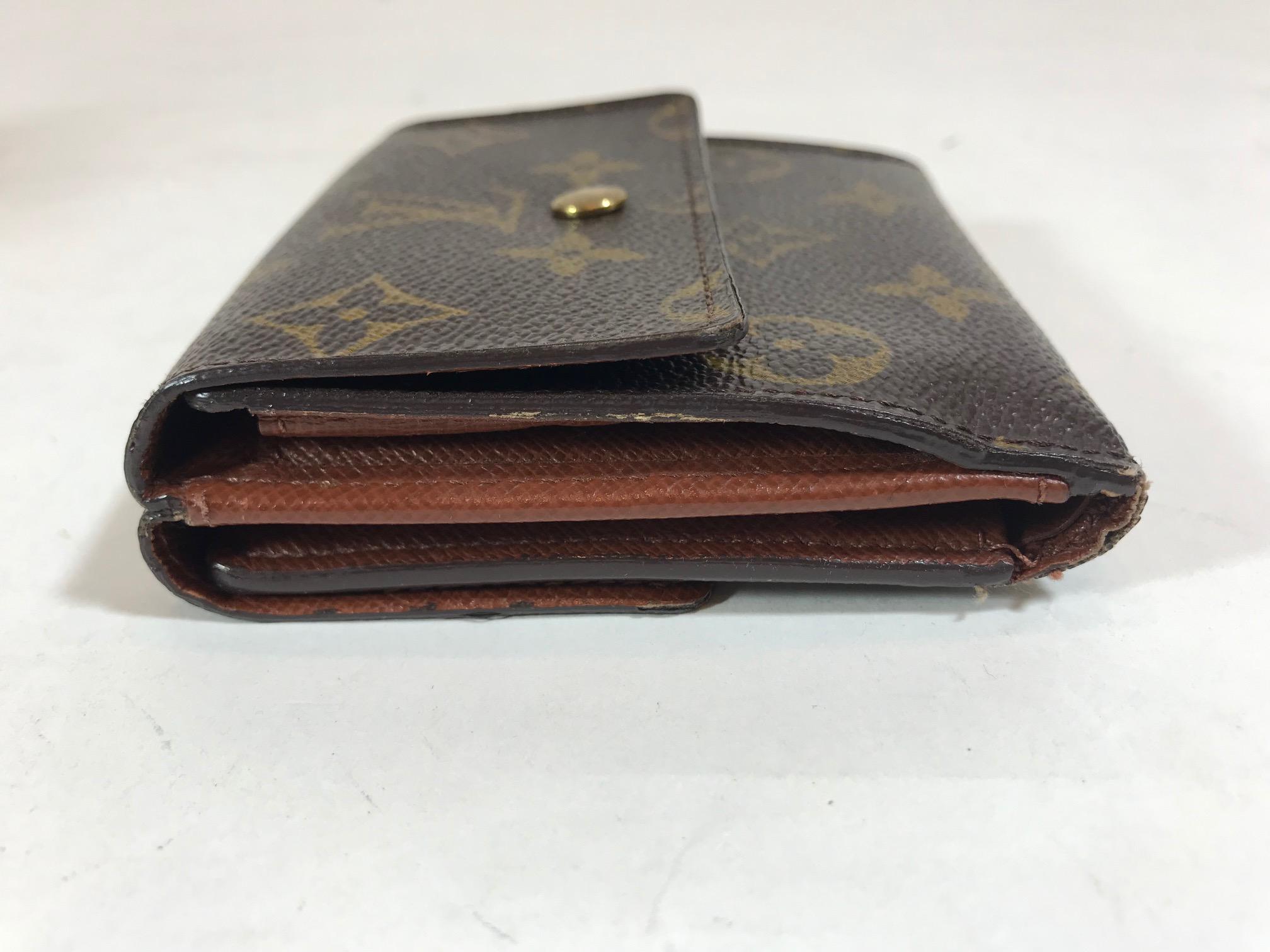 Brown and tan monogram compact wallet. Brass hardware, single compartment at front featuring snap closure, tonal leather lining, single bill compartment at interior walls, six card slots and snap closure at back. Estimated Retail Price: $630