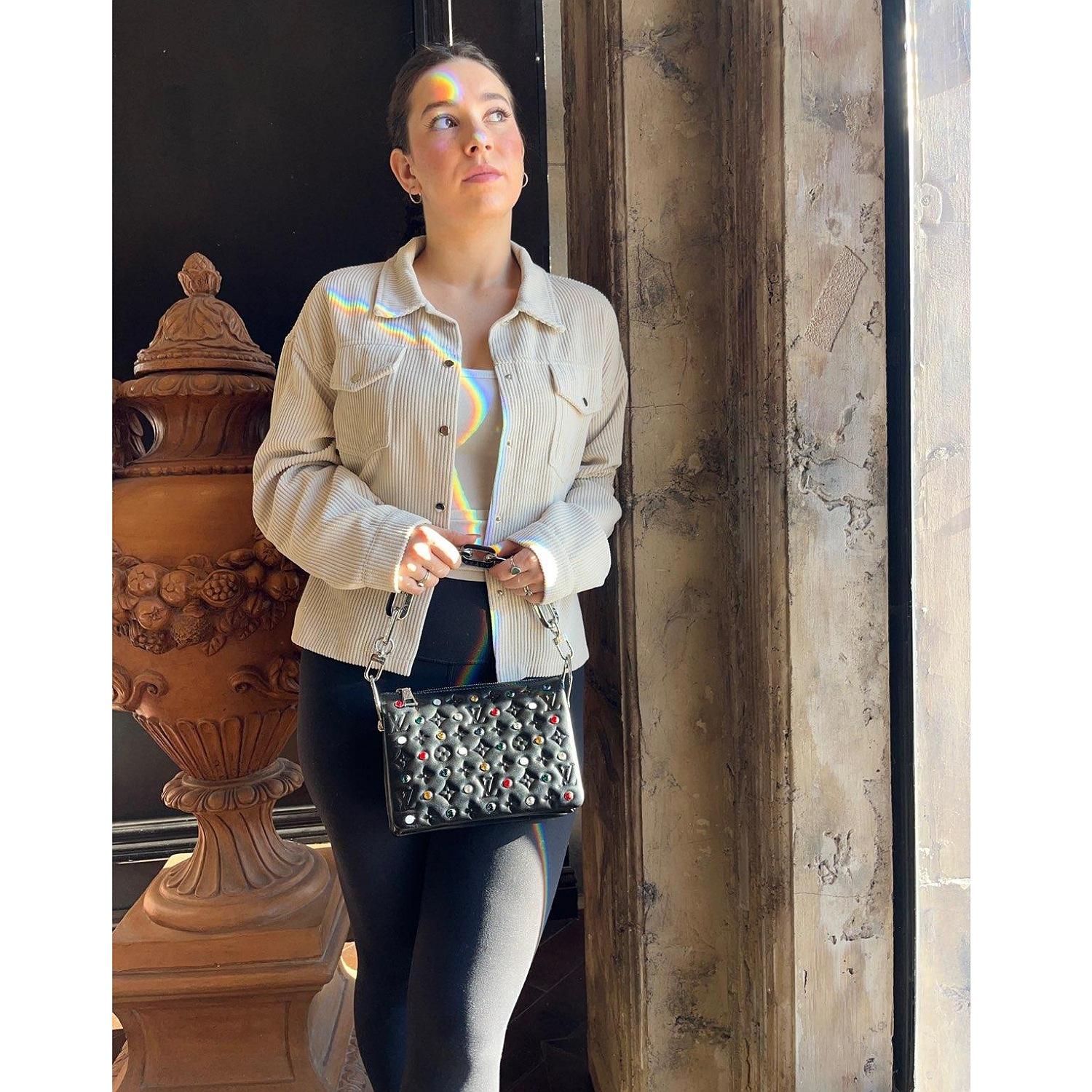 This shoulder bag is crafted of soft lambskin leather embossed in black. with embellished multicolored crystals throughout the exterior. The bag features a silver chain strap, an optional leather shoulder strap, and silver hardware. The top zipper