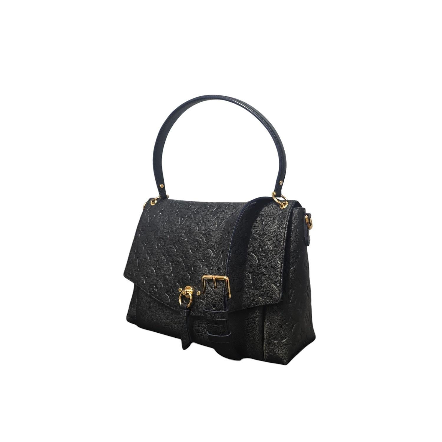 Ce Monogramme Empreinte Blanche de Louis Vuitton est réalisé en cuir luxueux Empreinte embossé du monogramme de Louis Vuitton, de couleur noire avec des glaçages bleus. Le sac est doté d'une bandoulière en cuir, d'une bandoulière réglable en cuir et