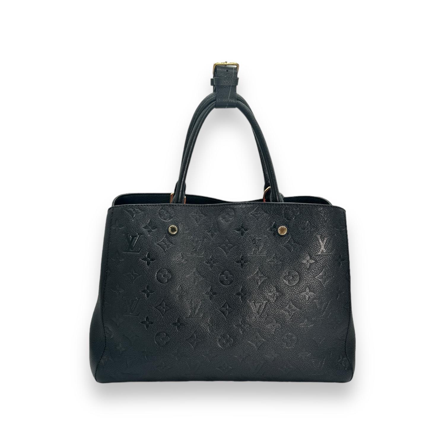 Diese schicke Handtasche ist aus schwarzem Leder mit Monogrammprägung von Louis Vuitton gefertigt. Die Handtasche hat gerollte Ledergriffe mit goldfarbenen Messinggliedern und eine breite, offene Klappe, die den Blick auf ein gestreiftes Stoffinnere