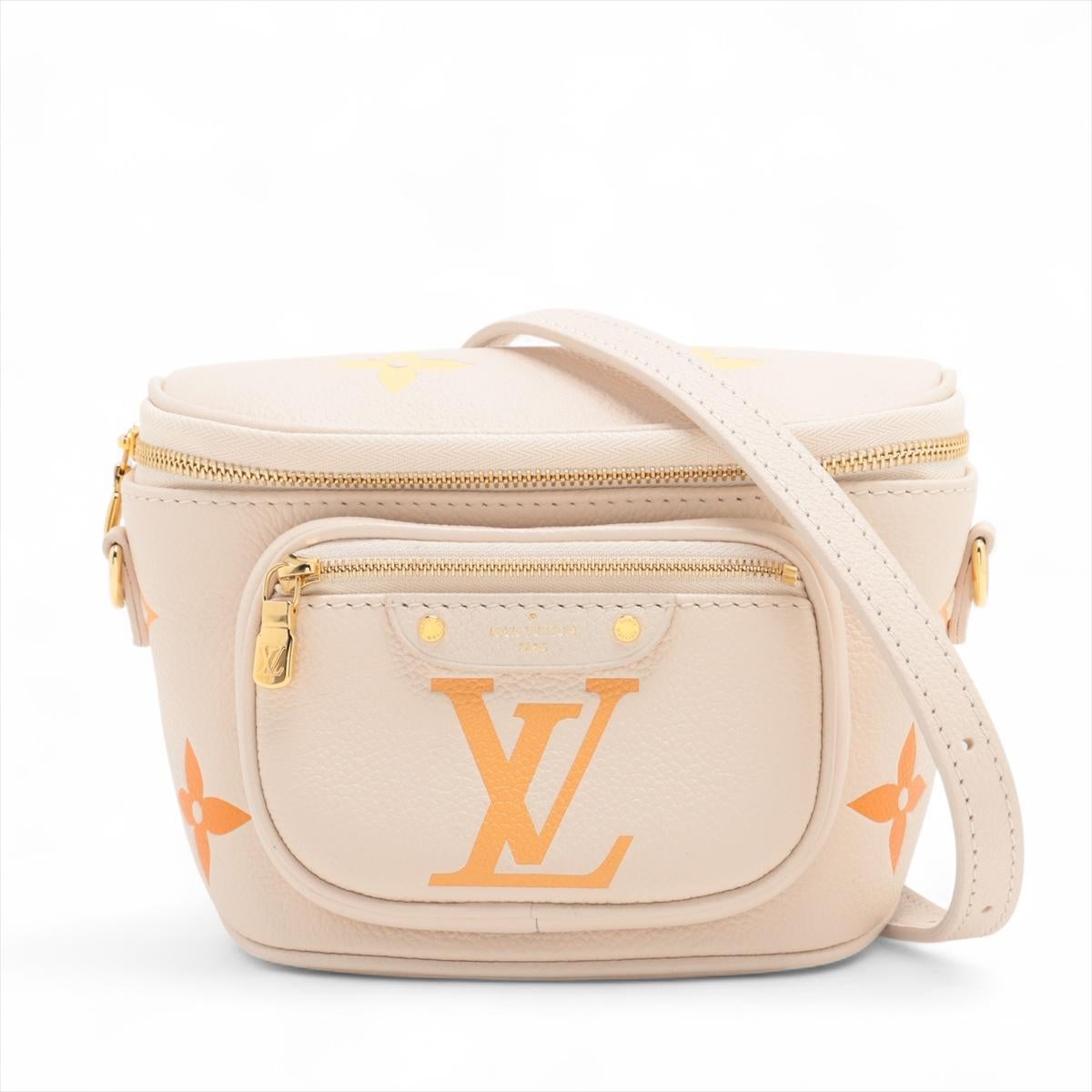 The Louis Vuitton Monogram Empreinte Mini Bumbag in Cream is a chic and compact accessory crafted from supple, embossed leather featuring the iconic Monogram pattern in gold. Despite its small size, the stylish bumbag offers a surprisingly spacious