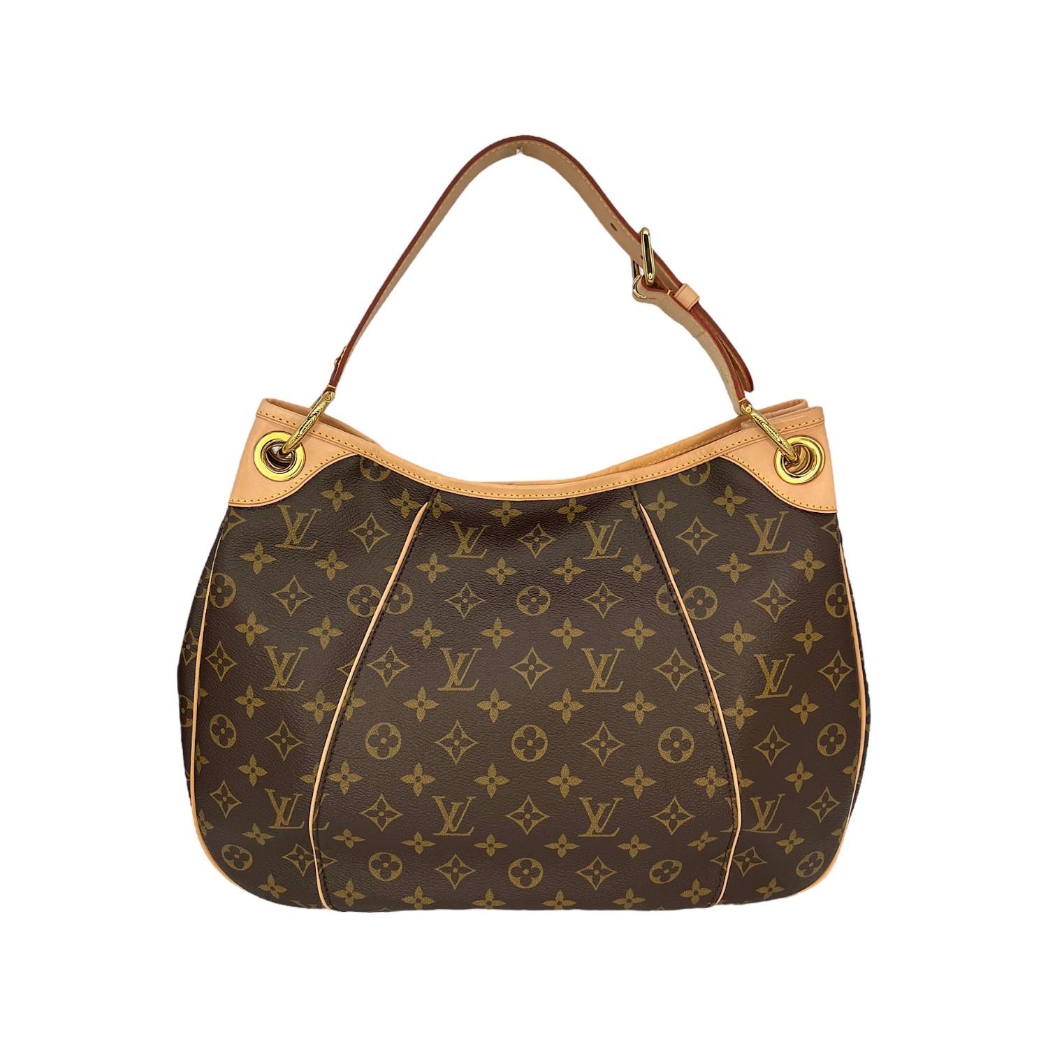 This Louis Vuitton Galleria PM was made in the USA and it is finely crafted of the Louis Vuitton Monogram coated canvas with leather trimming and gold-tone hardware features. It features a magnetic snap closure that opens up to a beige Alcantara