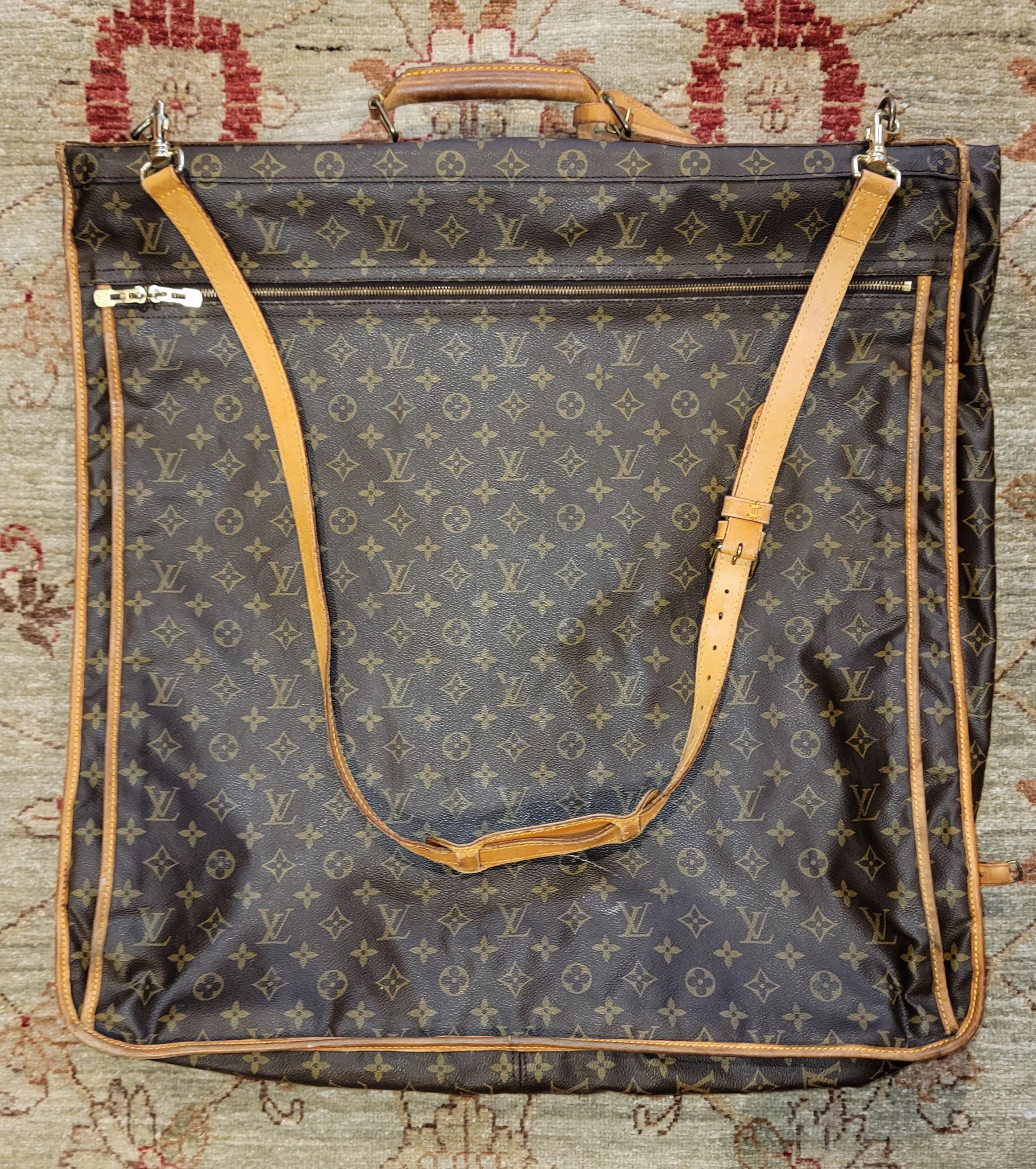 Louis Vuitton Monogram Garment Luggage Carrying Bag with 2 hangars.There is a hook on the bottom of the bag when opened can hang in a closet. Easily opened and cloths exposed when laying down to pull cothes out.LV leather straps and buckles on the