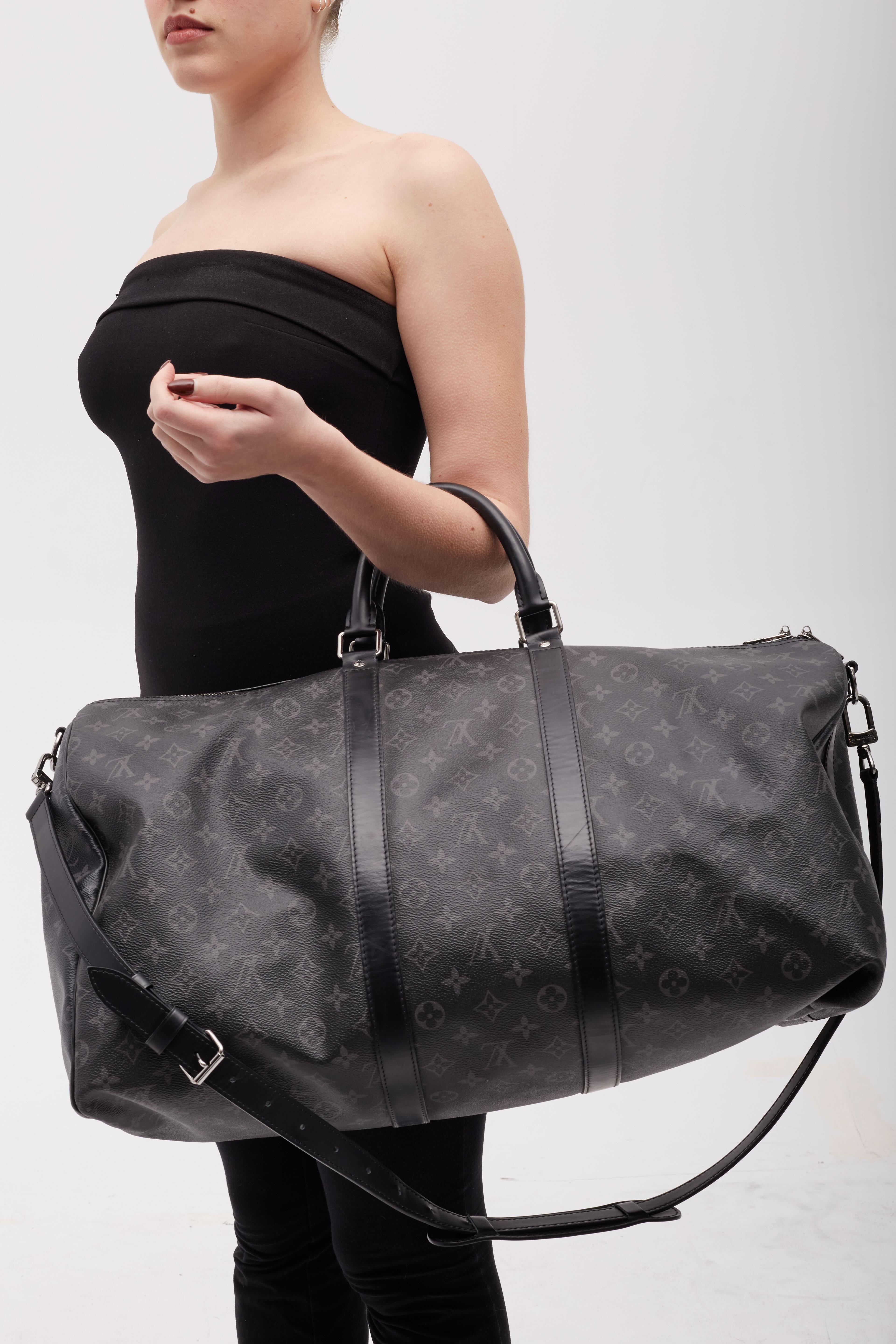 This iconic LV weekender bag is made of black coated canvas and features the damier graphite pattern, silver-tone hardware and leather trim throughout. Designed for both form The bag is finished with dual rolled leather top handles and top zip
