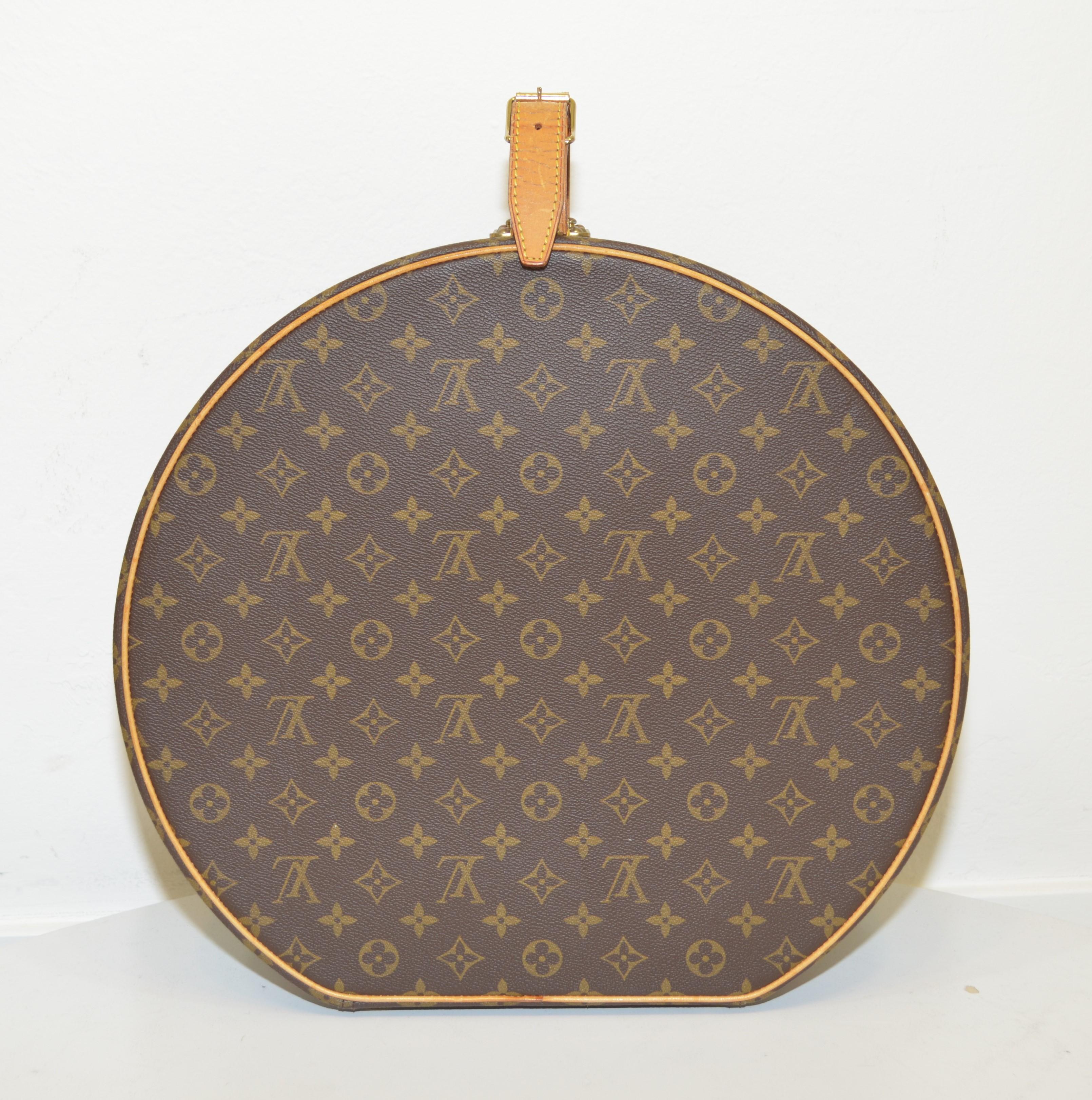Louis Vuitton hatbox is featured in the signature monogram print with tan leather trimmings and top handle with an adjustable buckle fastening. Interior is fully lined in a canvas fabric with one slip pocket. Hatbox is in great condition with some