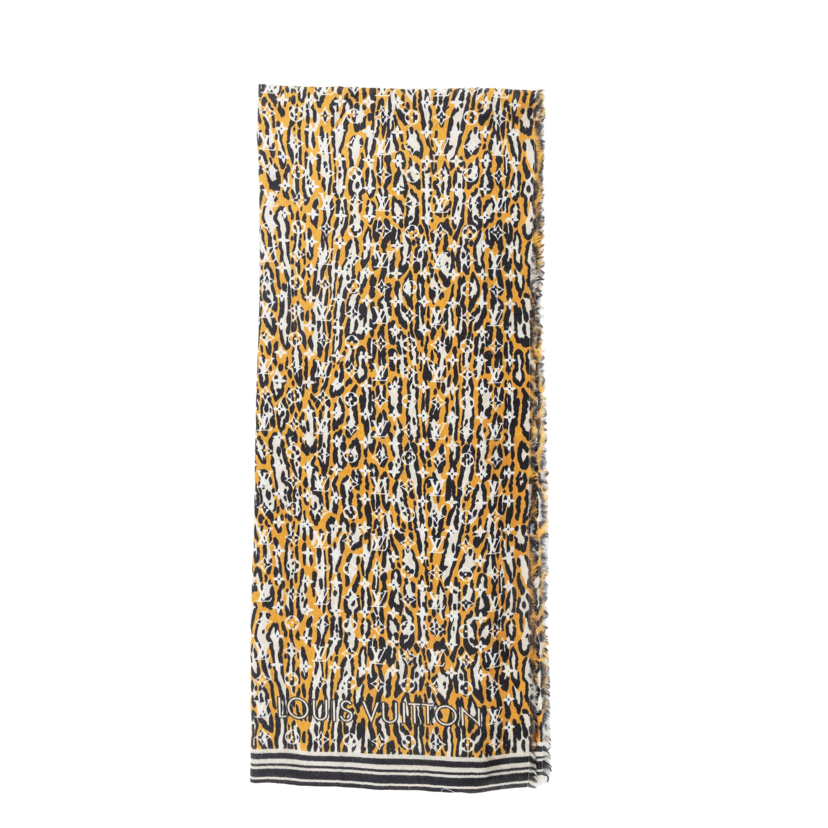 Wrap yourself in luxury and warmth with the Louis Vuitton Monogram Jungle Print Scarf. Made from 100% pure wool, this shawl showcases an intricate Epi pattern created through a combination of inkjet printing and jacquard techniques. Complete with a