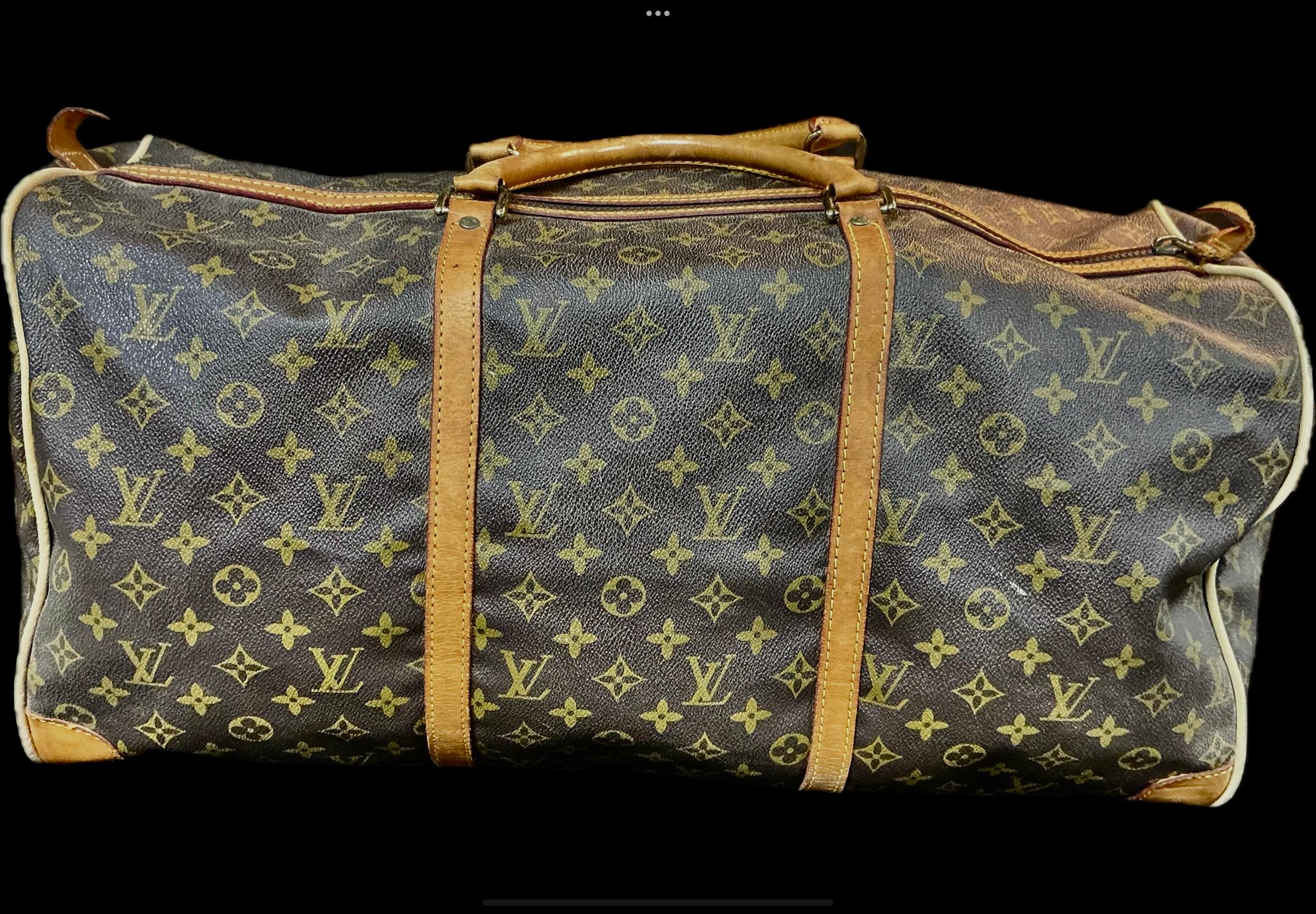Early 20th Century Louis Vuitton Duffle Bag features iconic brown monogrammed bag with solid leather rolled handles and trim with brass hardware. Bag has a top zipper closure, an interior small zipper pocket with a stitched Louis Vuitton tag,