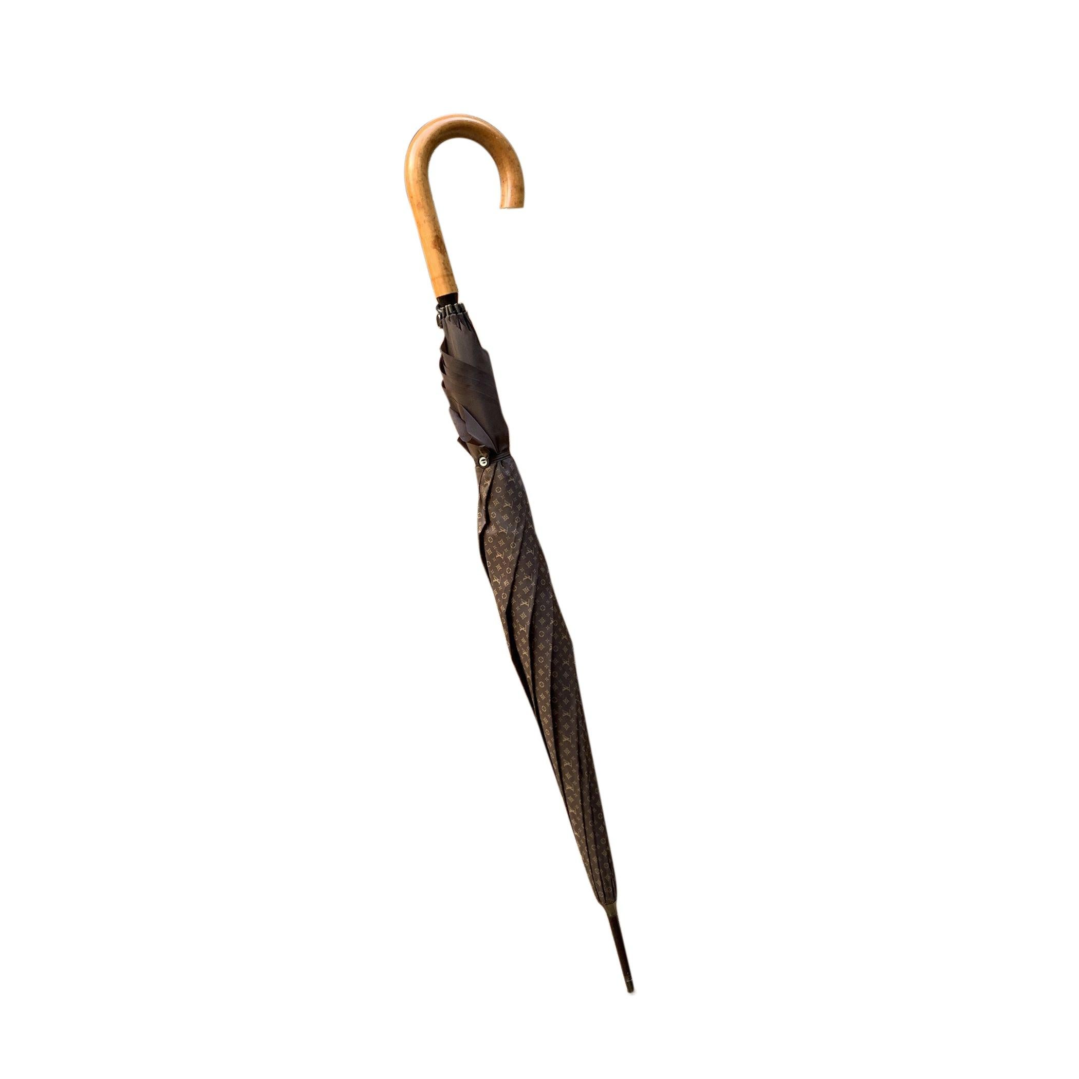 Elevate your accessory collection with this vintage Louis Vuitton Monogram Umbrella, a true testament to the brand's iconic craftsmanship and timeless style. Featuring the signature brown monogram pattern, this umbrella offers a vintage, handmade